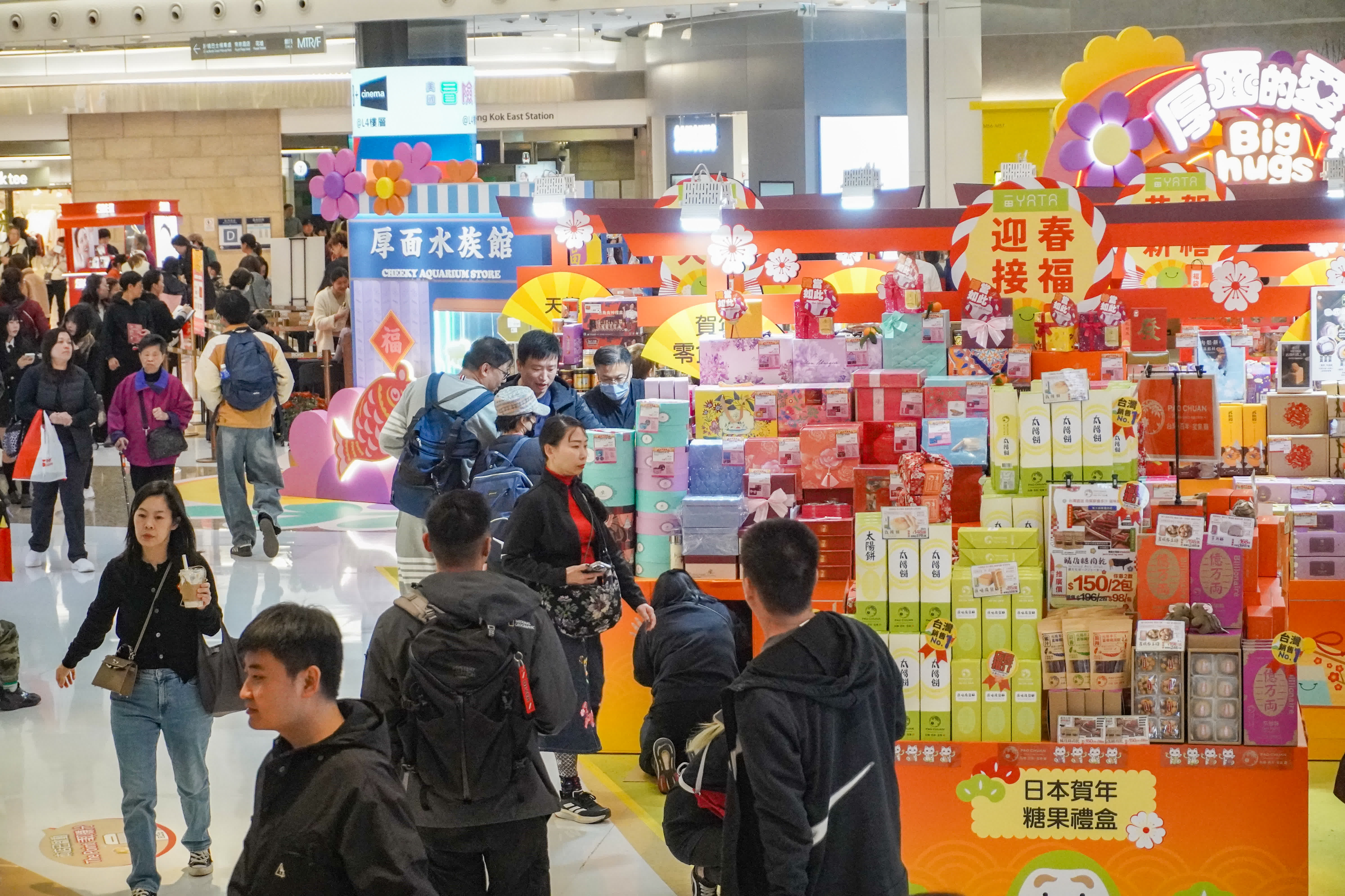 圖為旺角東一間商場，年貨鋪位火爆，人流眾多，商場亦派發揮春吸引市民。（香港中通社）