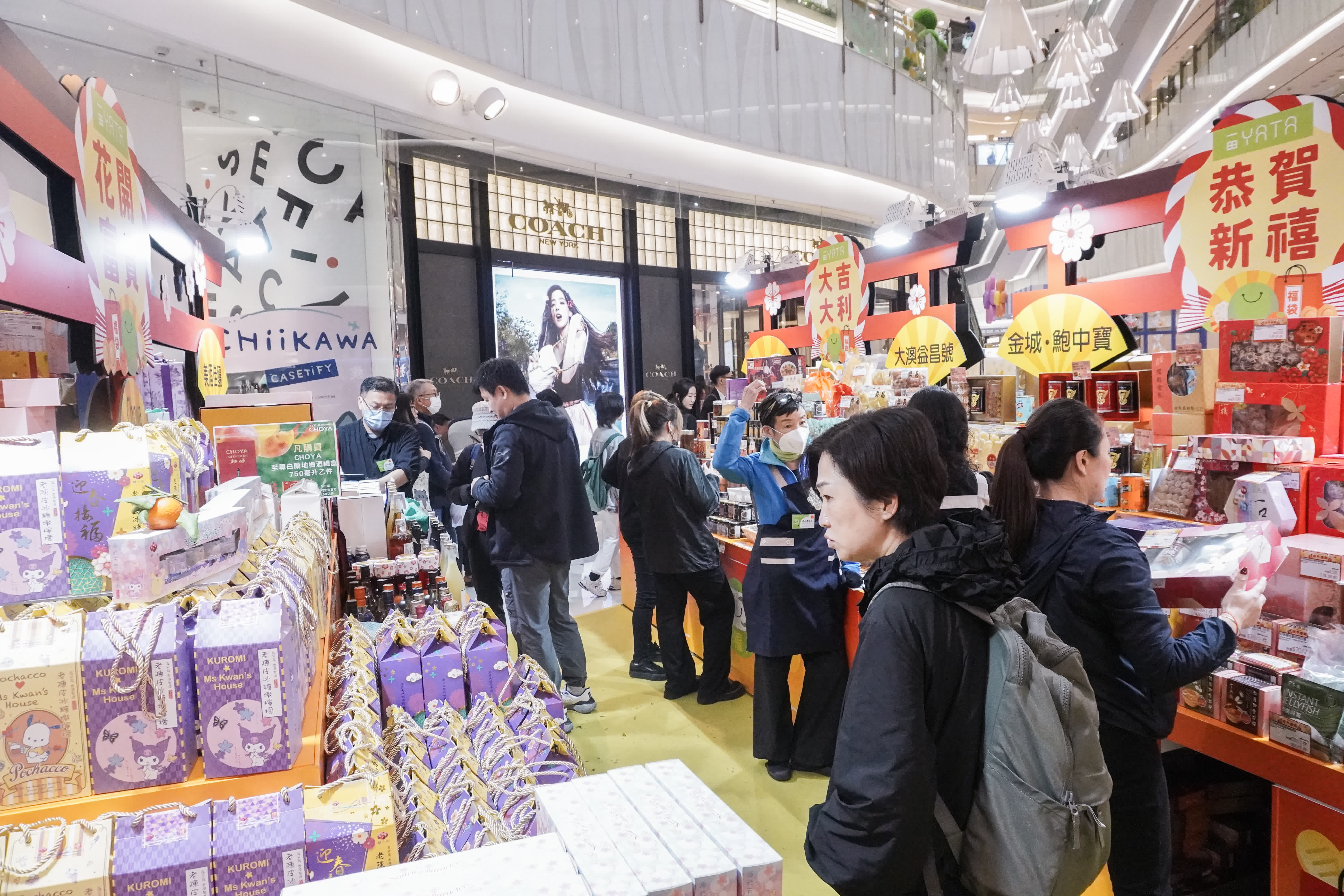 圖為旺角東一間商場，年貨鋪位火爆，人流眾多，商場亦派發揮春吸引市民。（香港中通社）