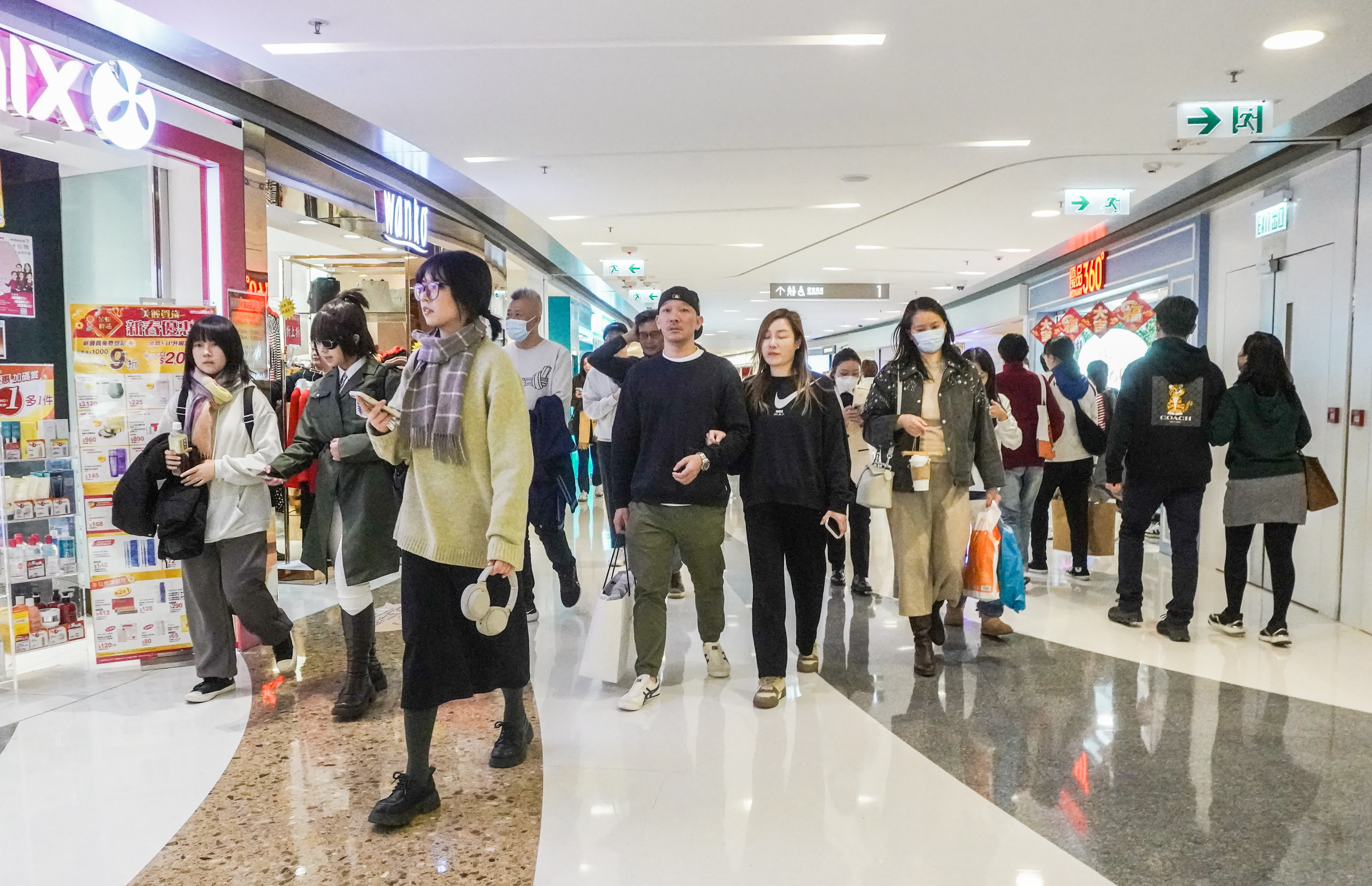 圖為旺角東一間商場，年貨鋪位火爆，人流眾多，商場亦派發揮春吸引市民。（香港中通社）