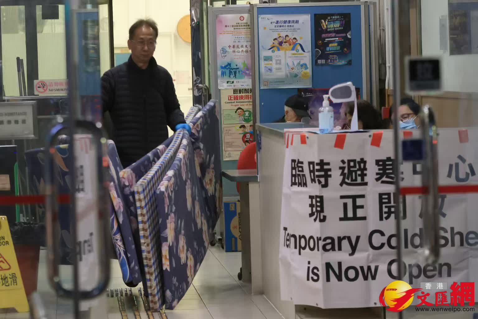寒冷天氣警告及強烈季候風信號現正生效。油麻地梁顯利避寒中心,職員忙於搬運床墊給有需要人士。 (香港文匯報記者北山彥 攝) 寒冷天氣警告及強烈季候風信號現正生效。油麻地梁顯利避寒中心,職員忙於搬運床墊給有需要人士。 (香港文匯報記者北山彥 攝)