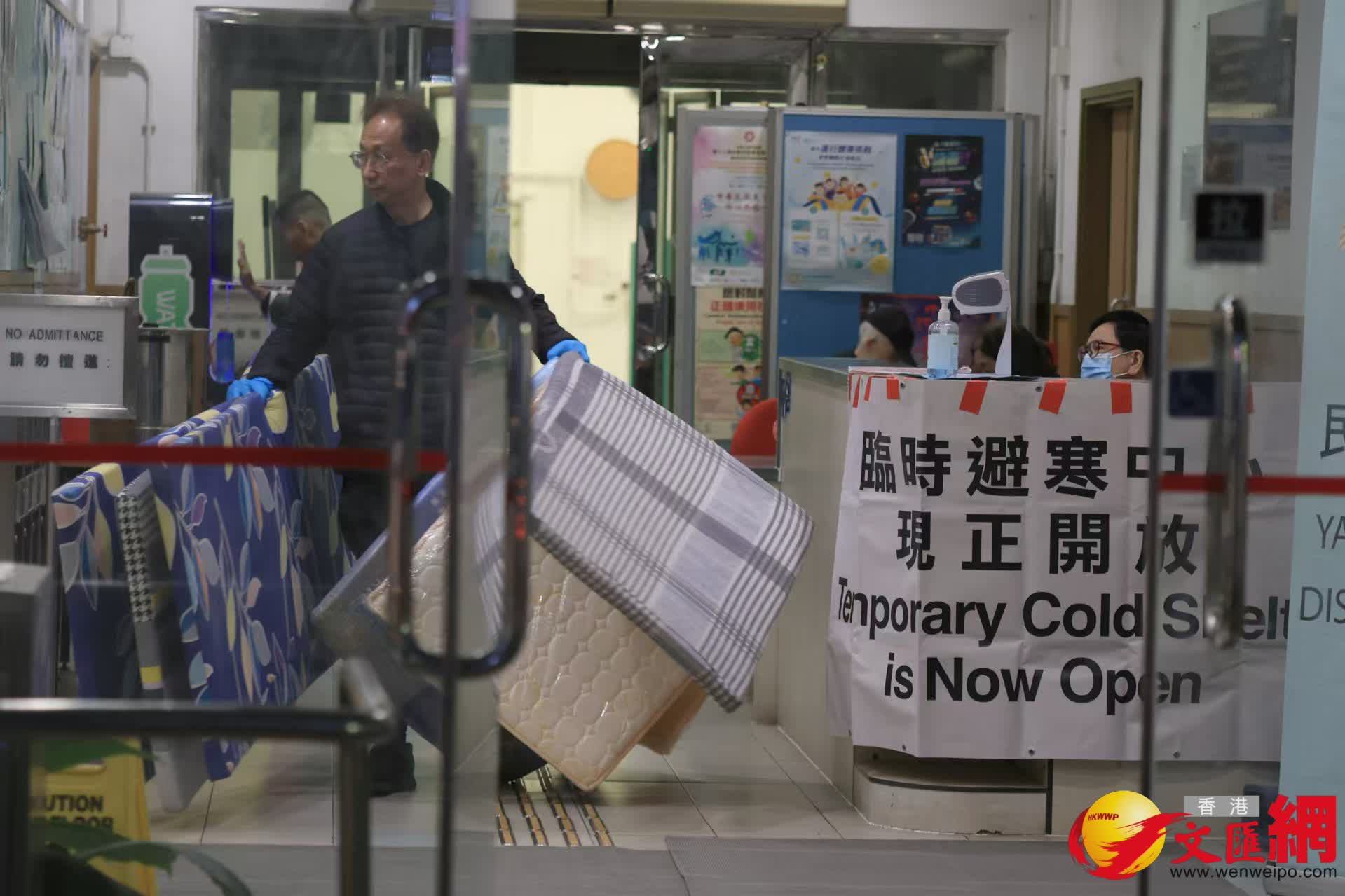 寒冷天氣警告及強烈季候風信號現正生效。油麻地梁顯利避寒中心,職員忙於搬運床墊給有需要人士。 (香港文匯報記者北山彥 攝) 寒冷天氣警告及強烈季候風信號現正生效。油麻地梁顯利避寒中心,職員忙於搬運床墊給有需要人士。 (香港文匯報記者北山彥 攝)