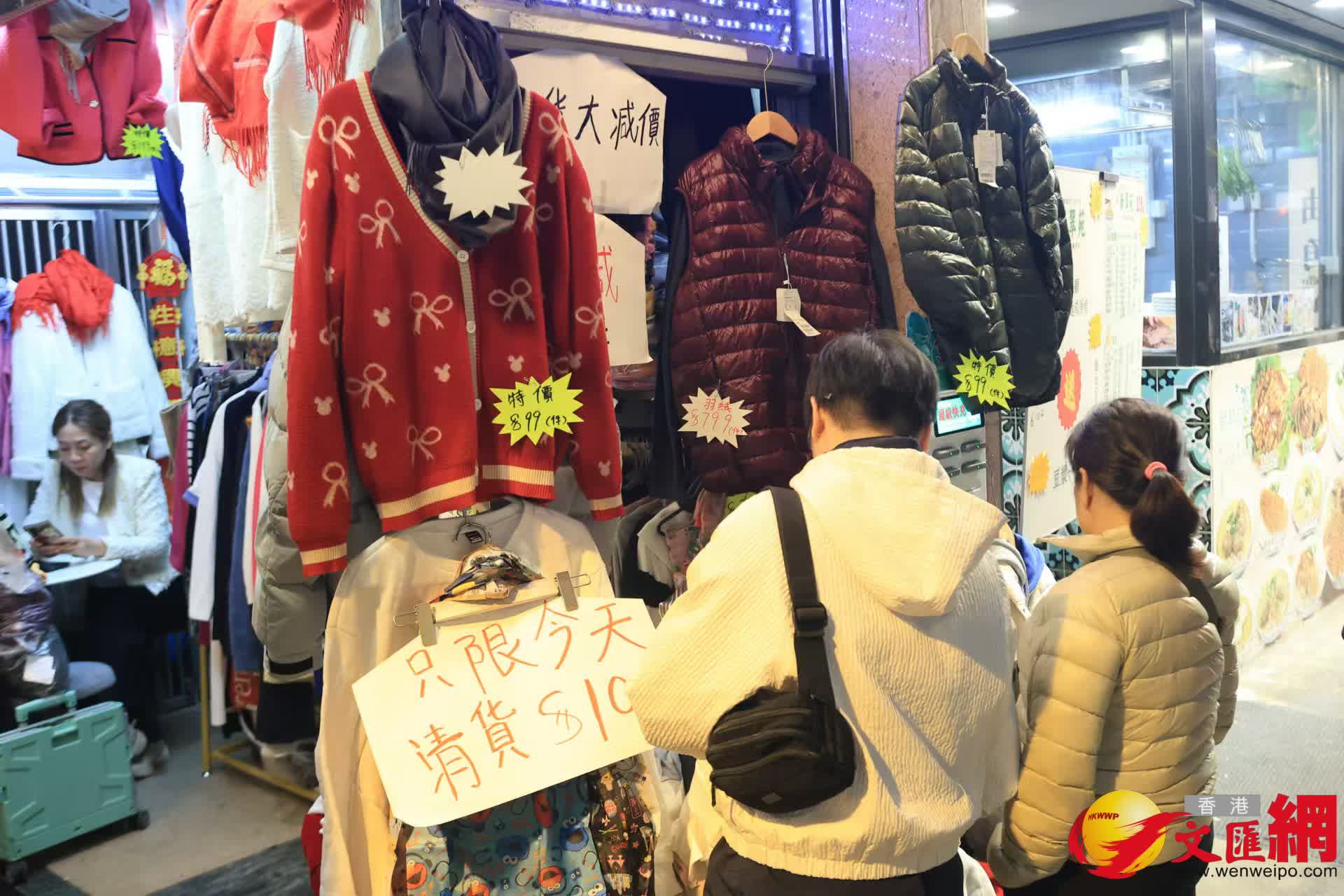 寒冷天氣警告及強烈季候風信號現正生效。天氣寒冷有市民即時街上添購禦寒羽絨保暖。 (香港文匯報記者北山彥 攝) 寒冷天氣警告及強烈季候風信號現正生效。天氣寒冷有市民即時街上添購禦寒羽絨保暖。 (香港文匯報記者北山彥 攝)
