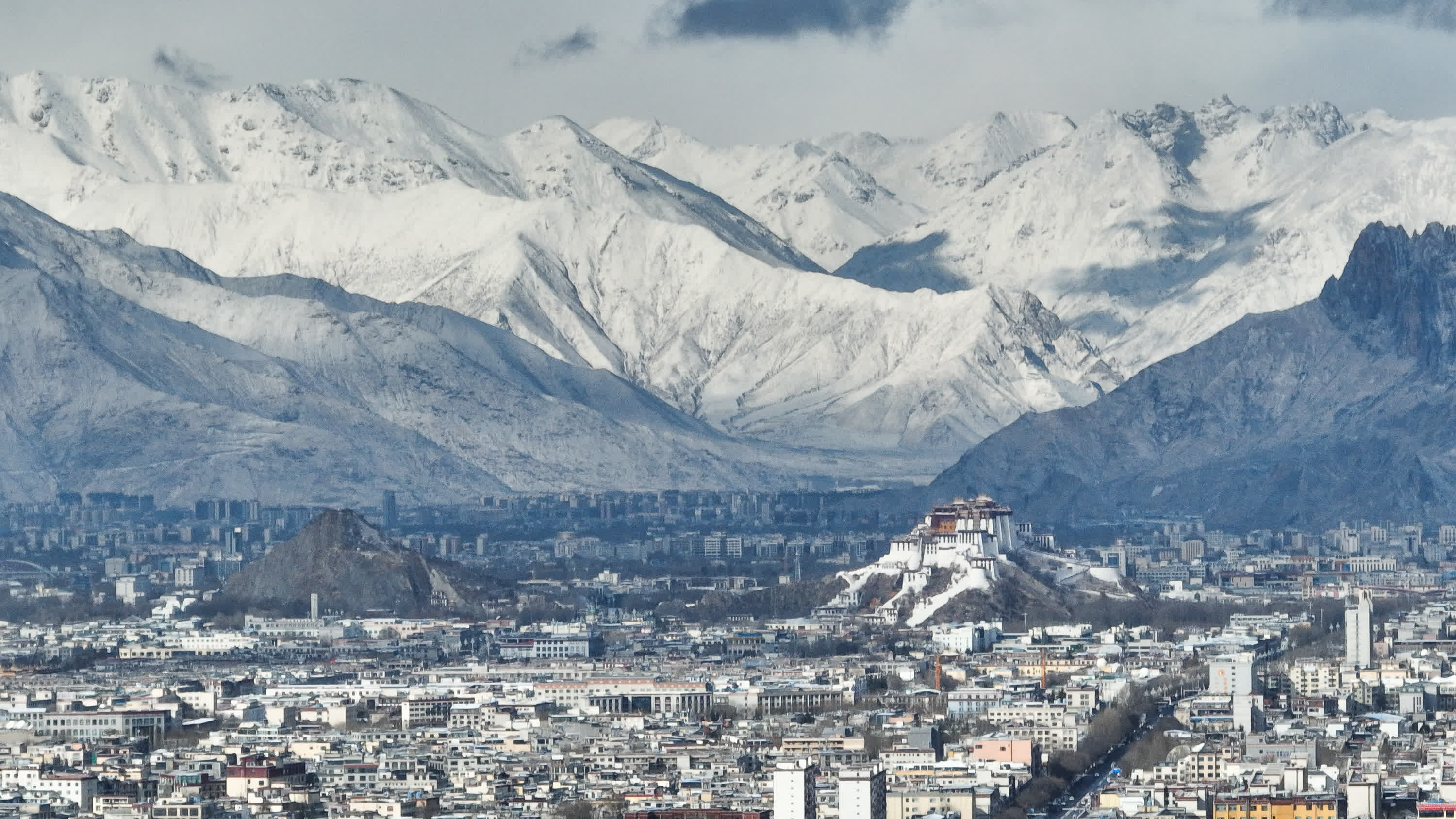 這是2月16日拍攝的降雪後的拉薩市區(qū)（無(wú)人機(jī)照片）。（新華社）