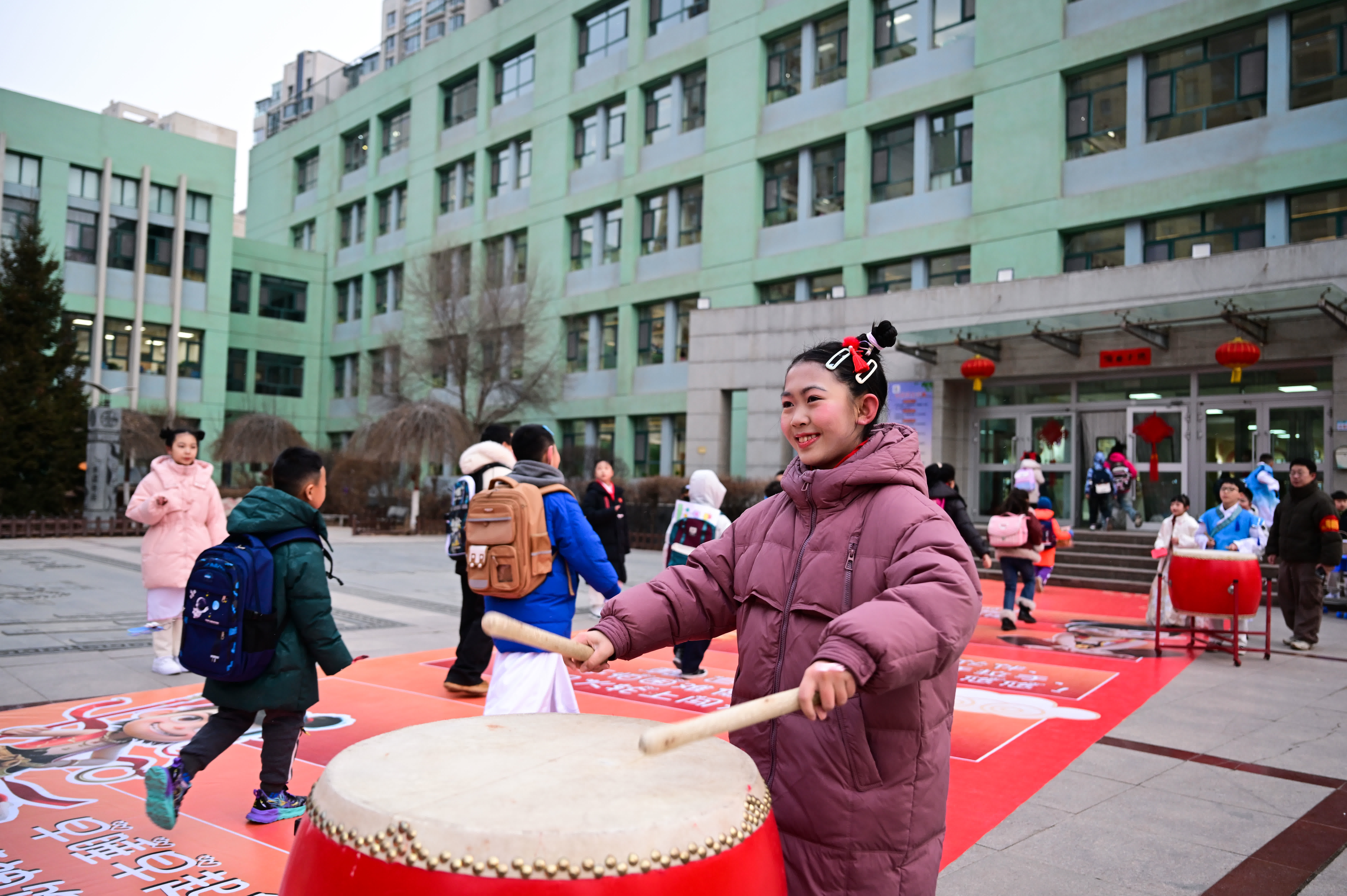 2月23日，西寧市城西區(qū)文匯小學(xué)一名裝扮成「哪吒」造型的學(xué)生在敲鼓歡迎同學(xué)入校。（新華社）