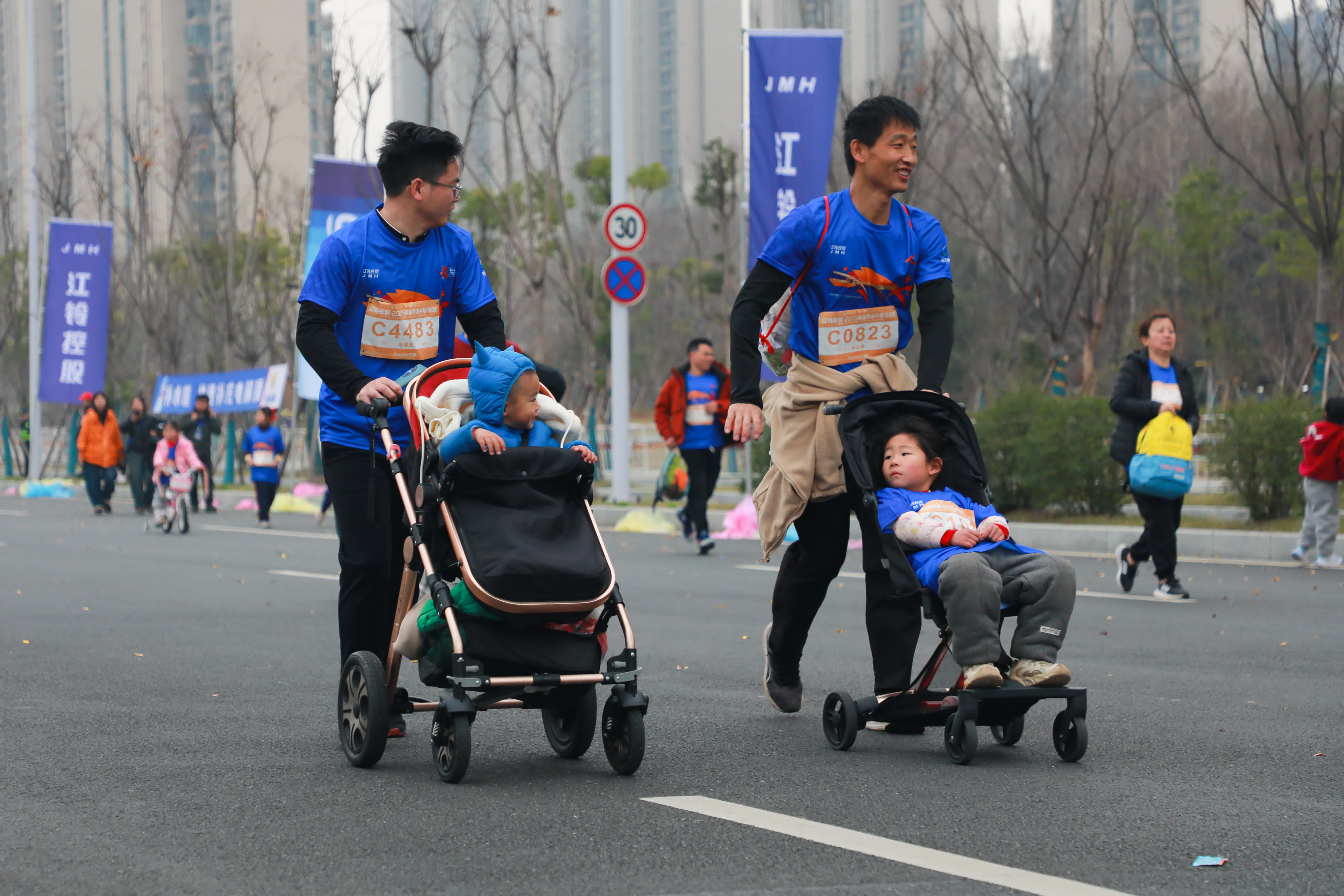 圖為兩位選手推著孩子共同奔跑前行。（中新社）