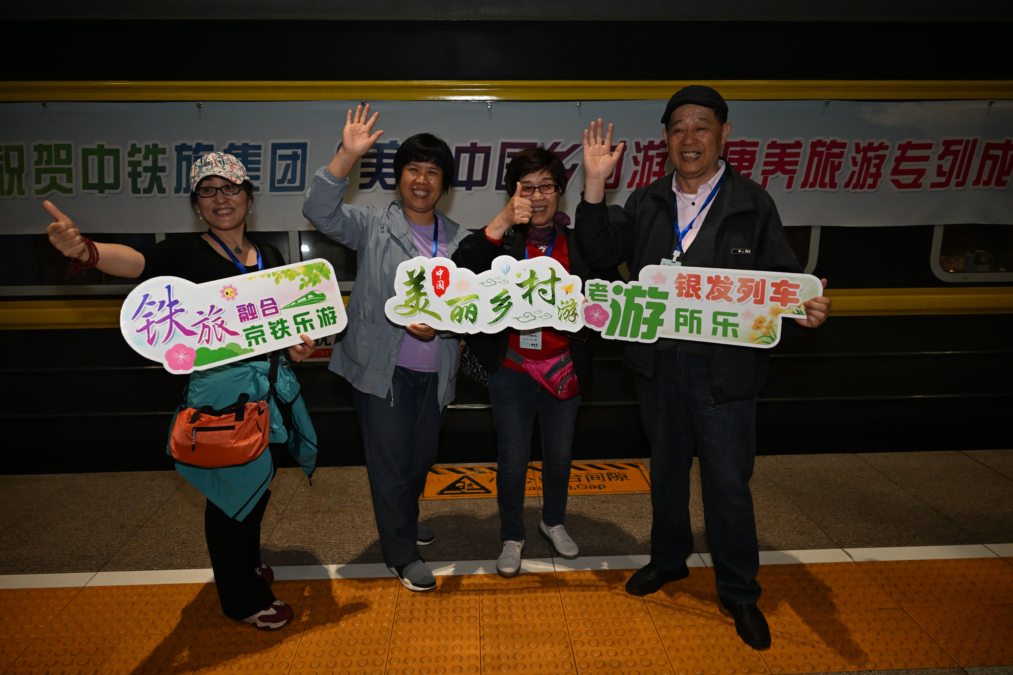 4月16日，在北京豐臺(tái)站，旅客在「美麗中國(guó)鄉(xiāng)村遊」康養(yǎng)旅遊專列前合影。（新華社）