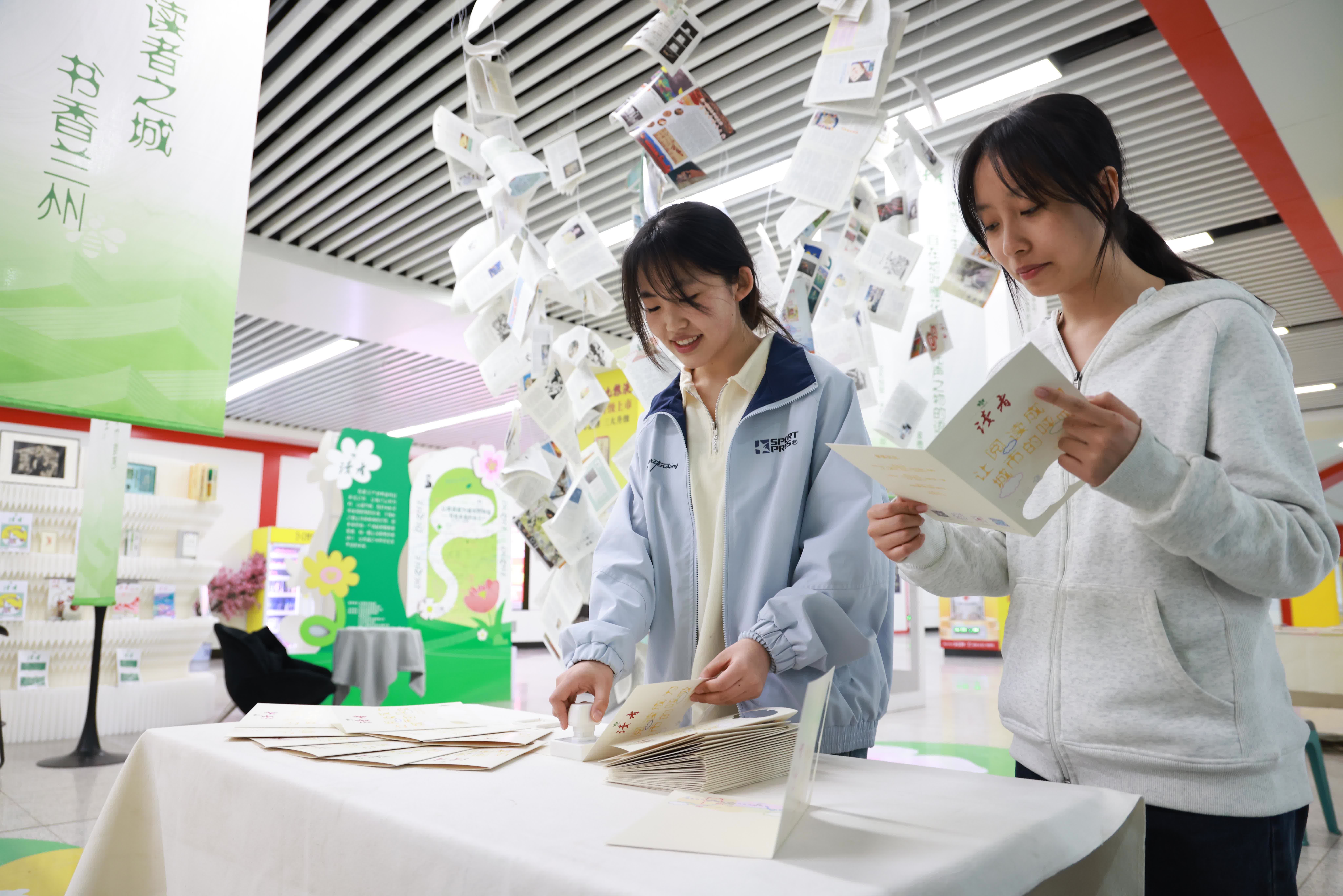 4月21日，市民在甘肅省蘭州市地鐵1號線東方紅廣場站「讀者·文化生活島」主題快閃店內體驗集章打卡文創活動。（新華社）