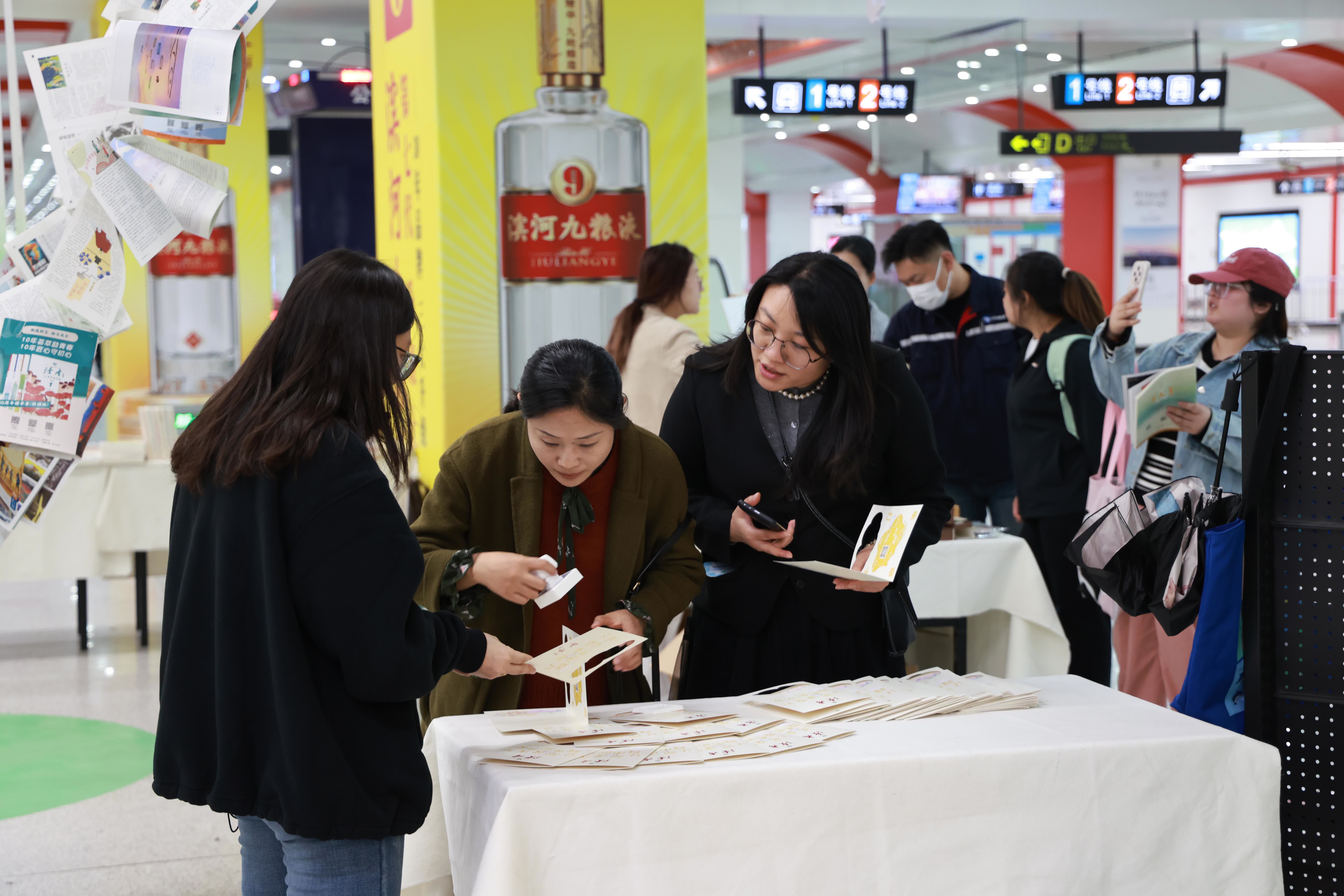 4月21日，市民在甘肅省蘭州市地鐵1號線東方紅廣場站「讀者·文化生活島」主題快閃店內體驗集章打卡文創活動。（新華社）