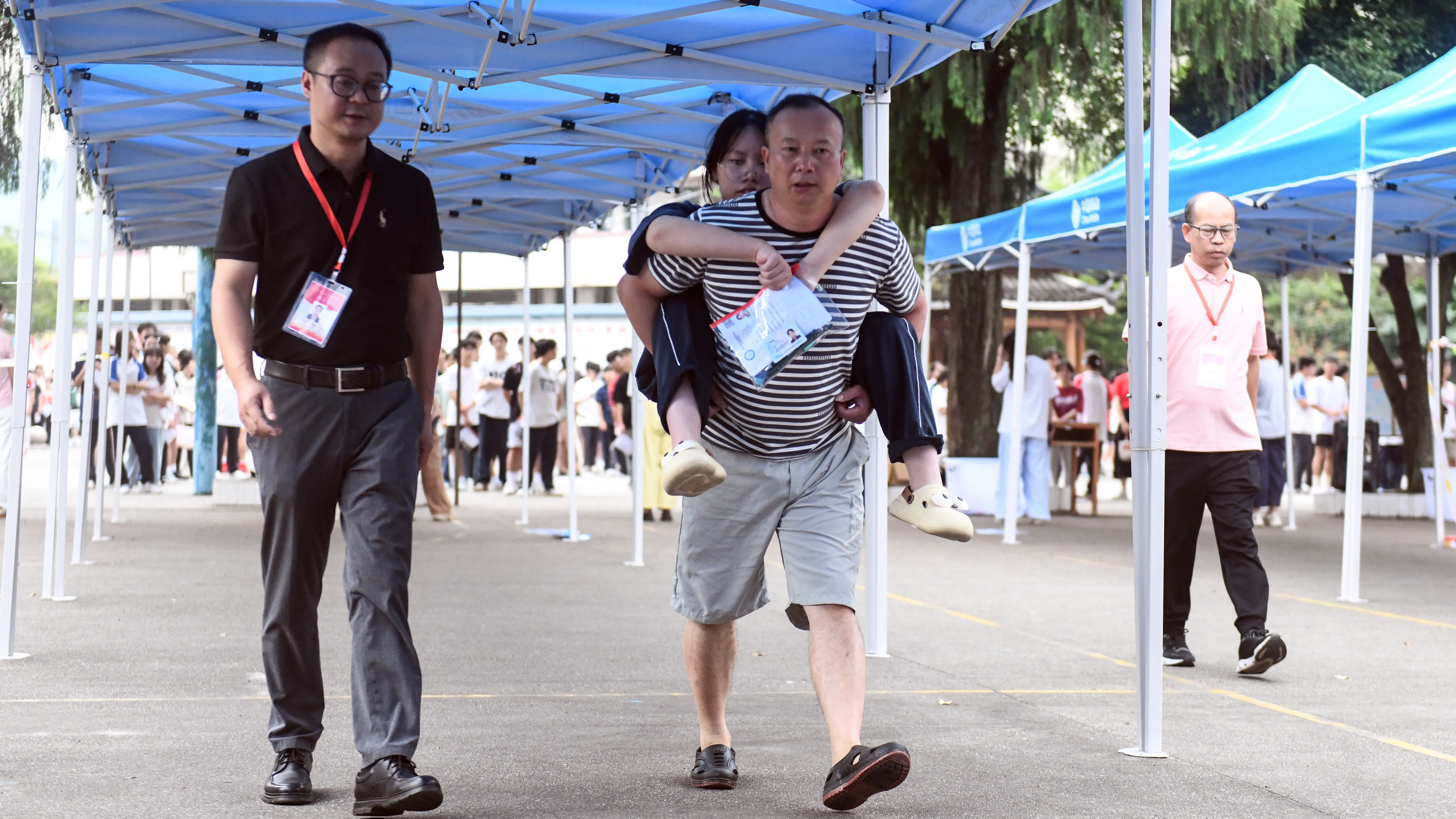 6月7日,一名家長在背送女兒進入廣西三江侗族自治縣三江中學考點。(新華社) 6月7日,一名家長在背送女兒進入廣西三江侗族自治縣三江中學考點。(新華社)