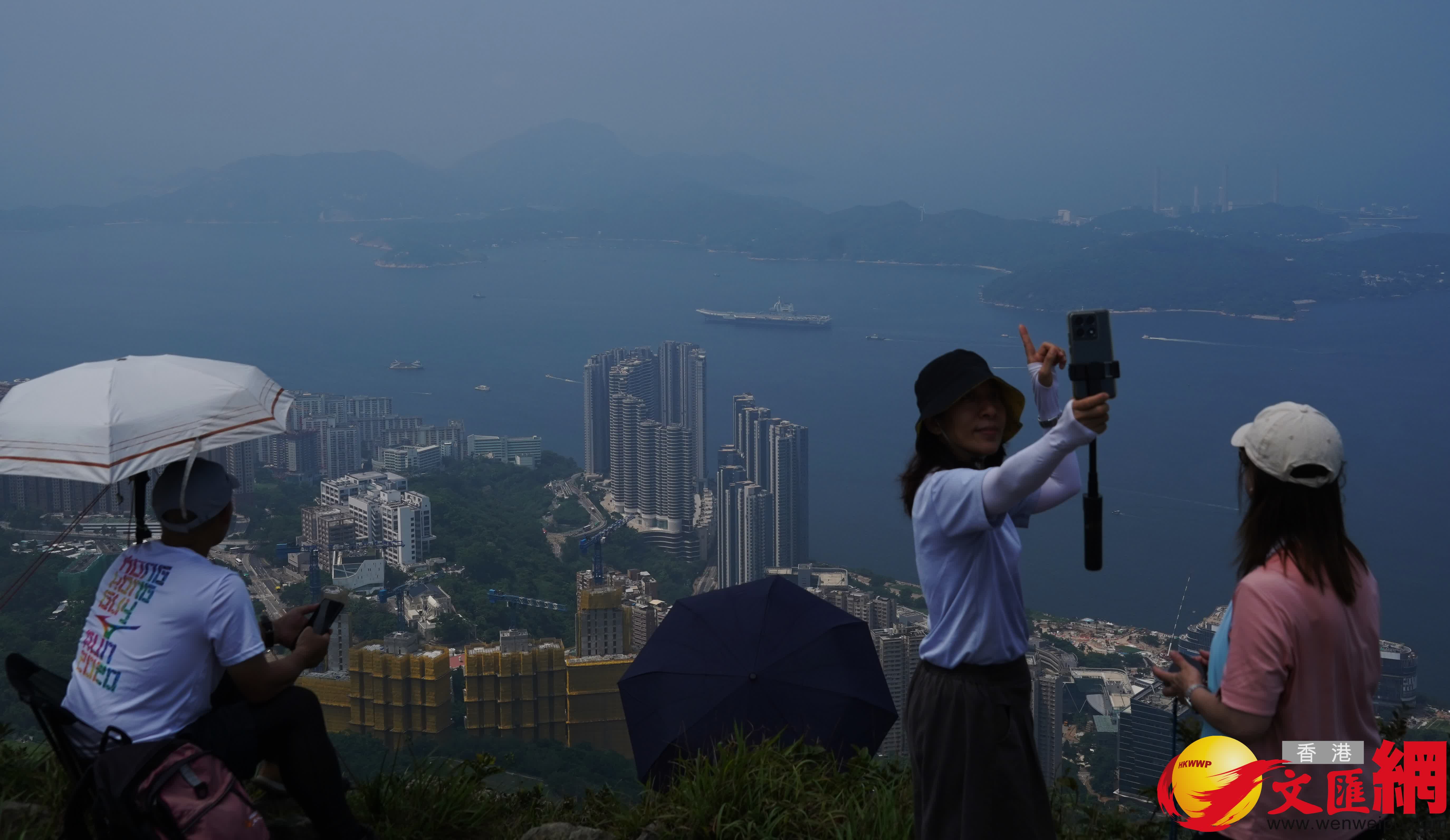 不少市民更專程到西高山目送山東艦離港一刻。 (香港文匯報記者曾興偉 攝) 不少市民更專程到西高山目送山東艦離港一刻。 (香港文匯報記者曾興偉 攝)