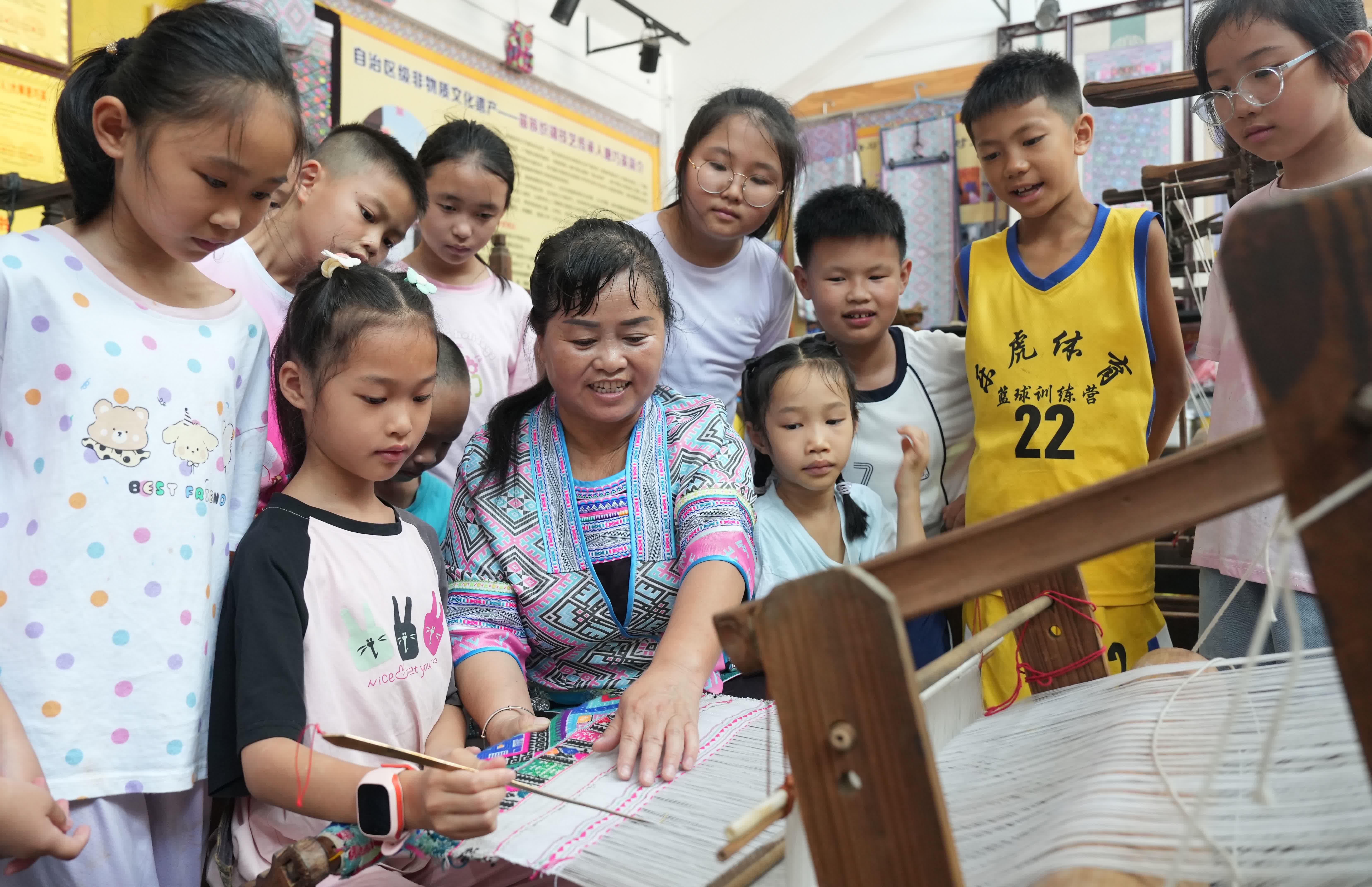 7月7日,在廣西柳州市融水苗族自治縣苗族織錦傳習體驗館,手工藝人唐巧英指導學生學習苗族織錦。(新華社) 7月7日,在廣西柳州市融水苗族自治縣苗族織錦傳習體驗館,手工藝人唐巧英指導學生學習苗族織錦。(新華社)