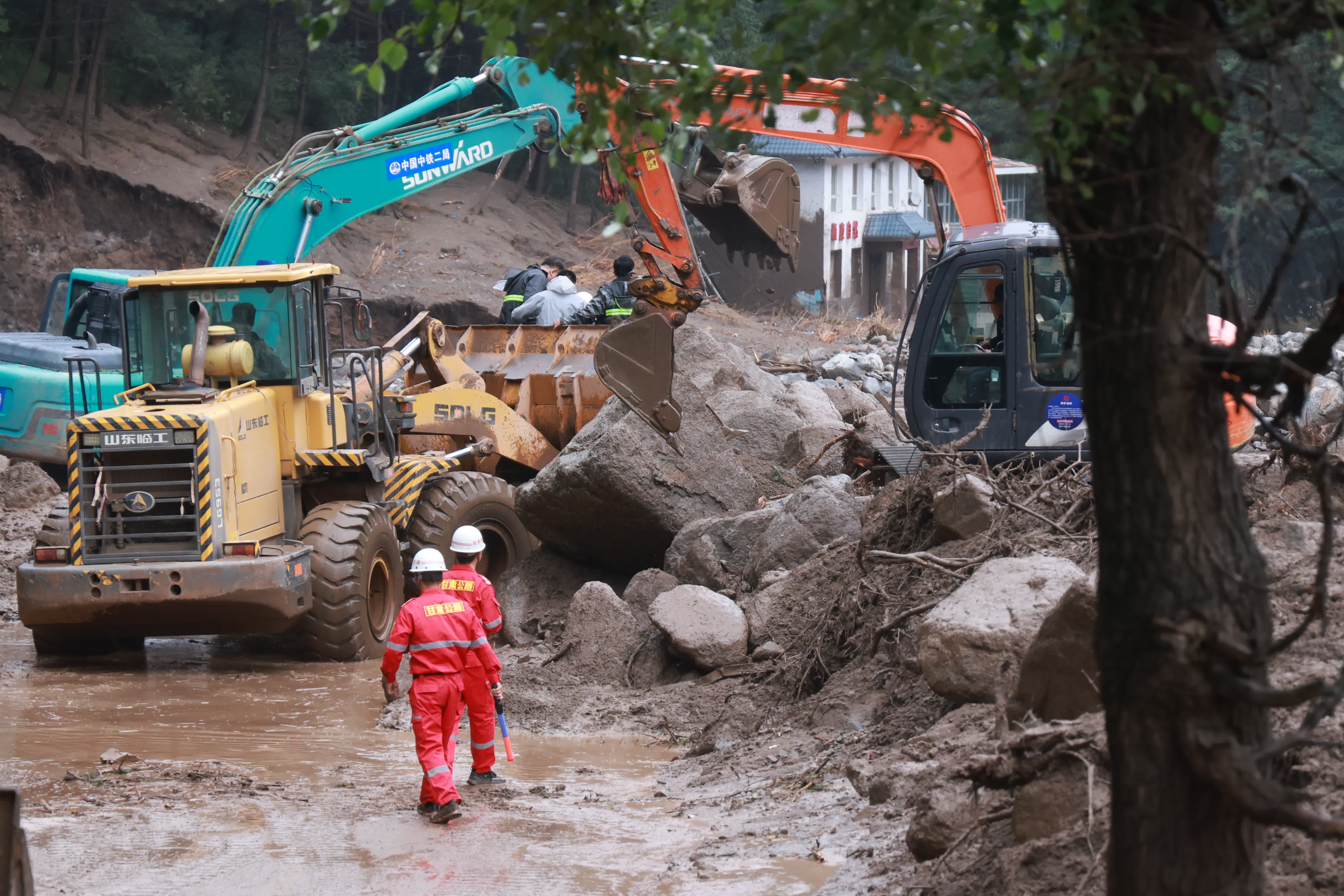 8月8日，救援人員在榆中縣馬坡鄉山洪災害現場搶修中斷道路。（新華社）