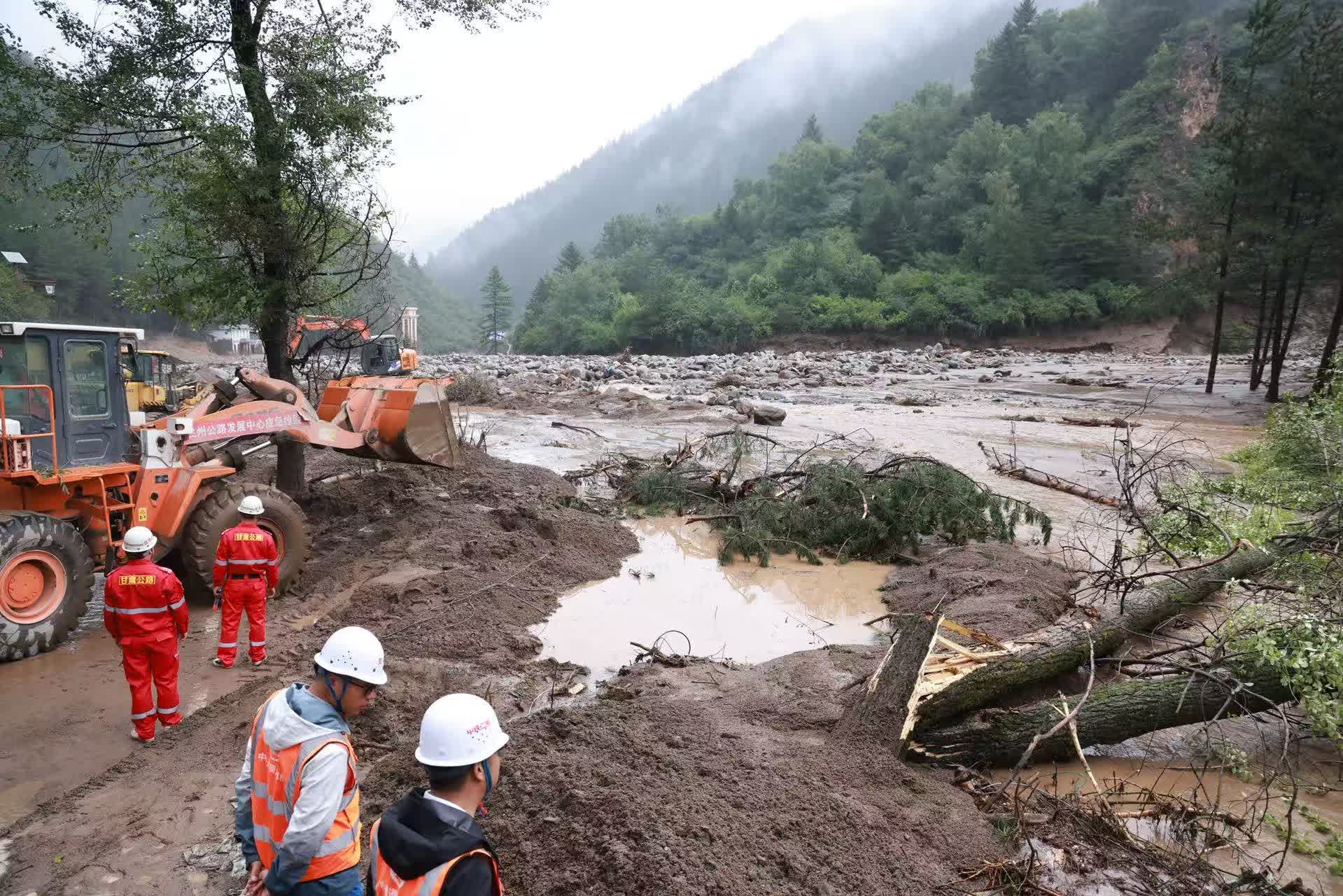 8月8日，救援人員在榆中縣馬坡鄉山洪災害現場搶修中斷道路。（新華社）