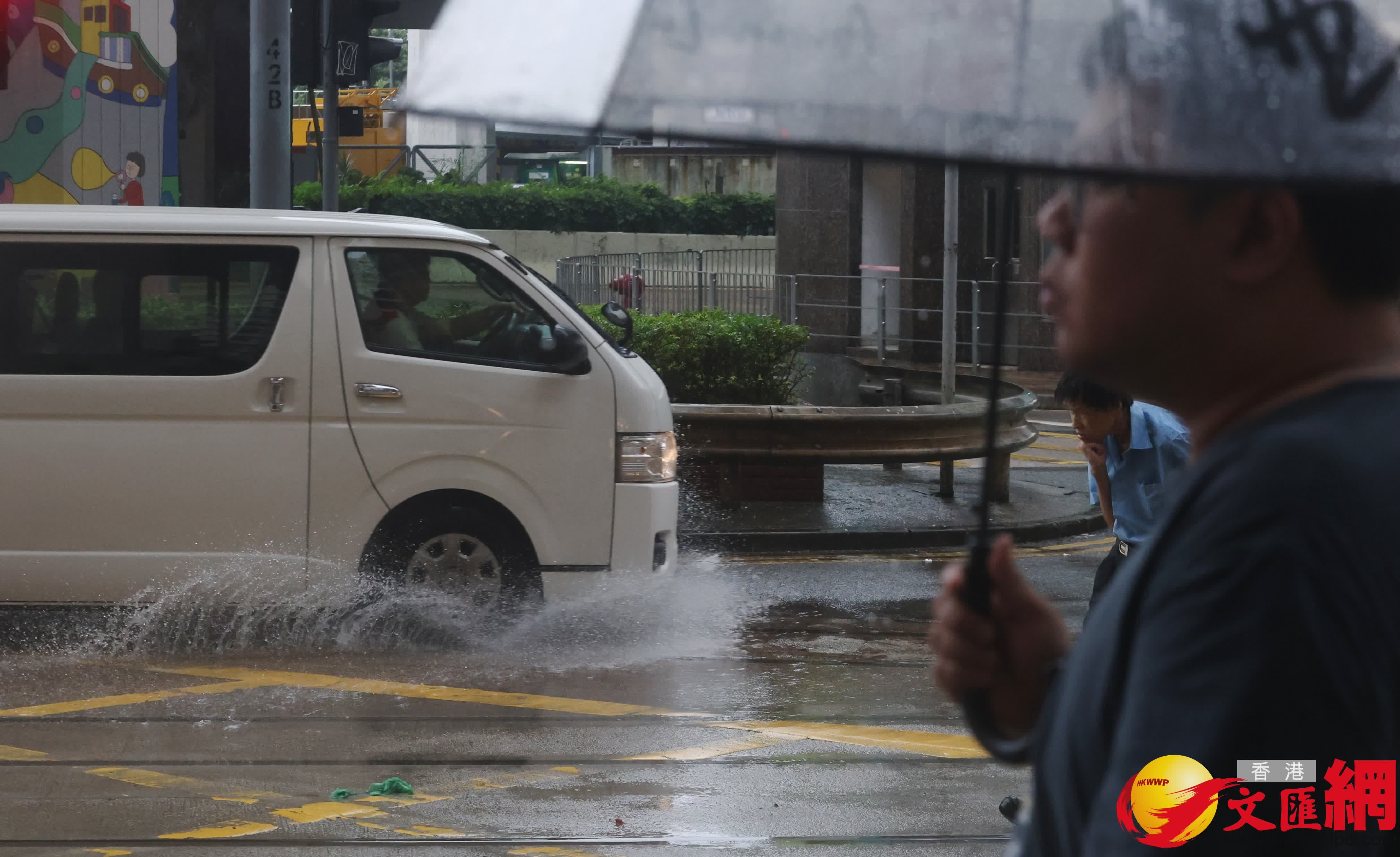 市民在黑雨警告信號下冒雨出行。（香港文匯報記者郭木又攝）