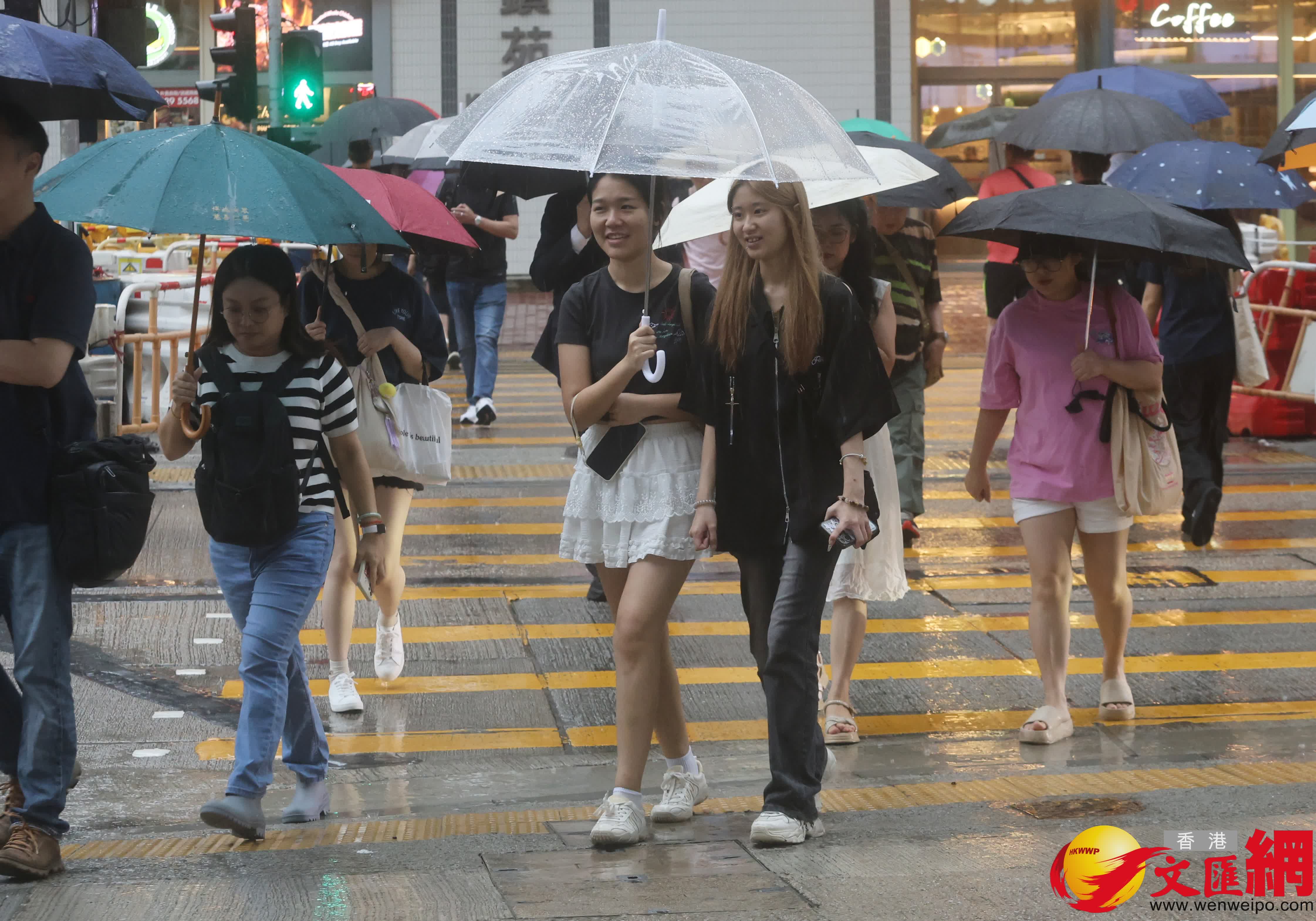 市民在黑雨警告信號下冒雨出行。（香港文匯報記者郭木又攝）