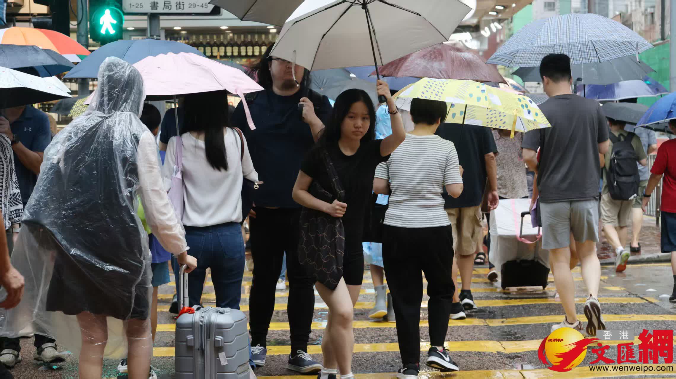 市民在黑雨警告信號下冒雨出行。（香港文匯報記者黃艾力攝）