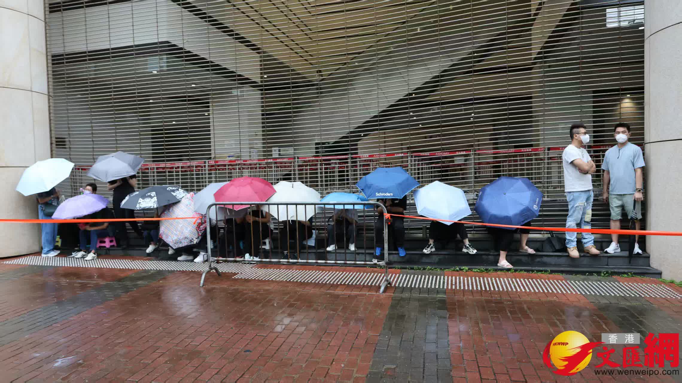 黎智英案倍受全港社會及中外媒體關注，媒體和市民冒雨在西九法院外守候。（香港文匯報記者 黃艾力 攝）