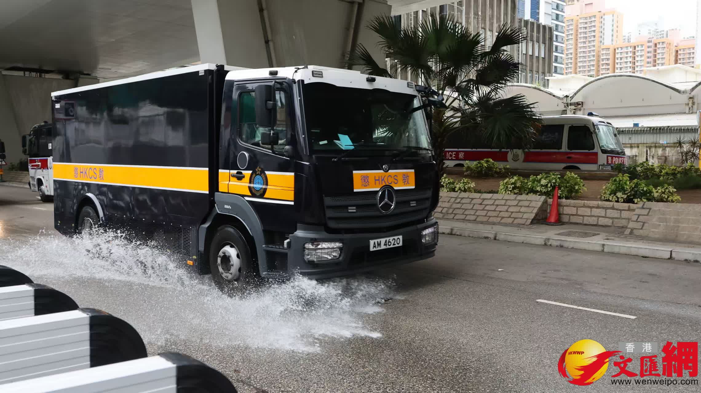 黎智英案倍受全港社會及中外媒體關注，媒體和市民冒雨在西九法院外守候。（香港文匯報記者 黃艾力 攝）