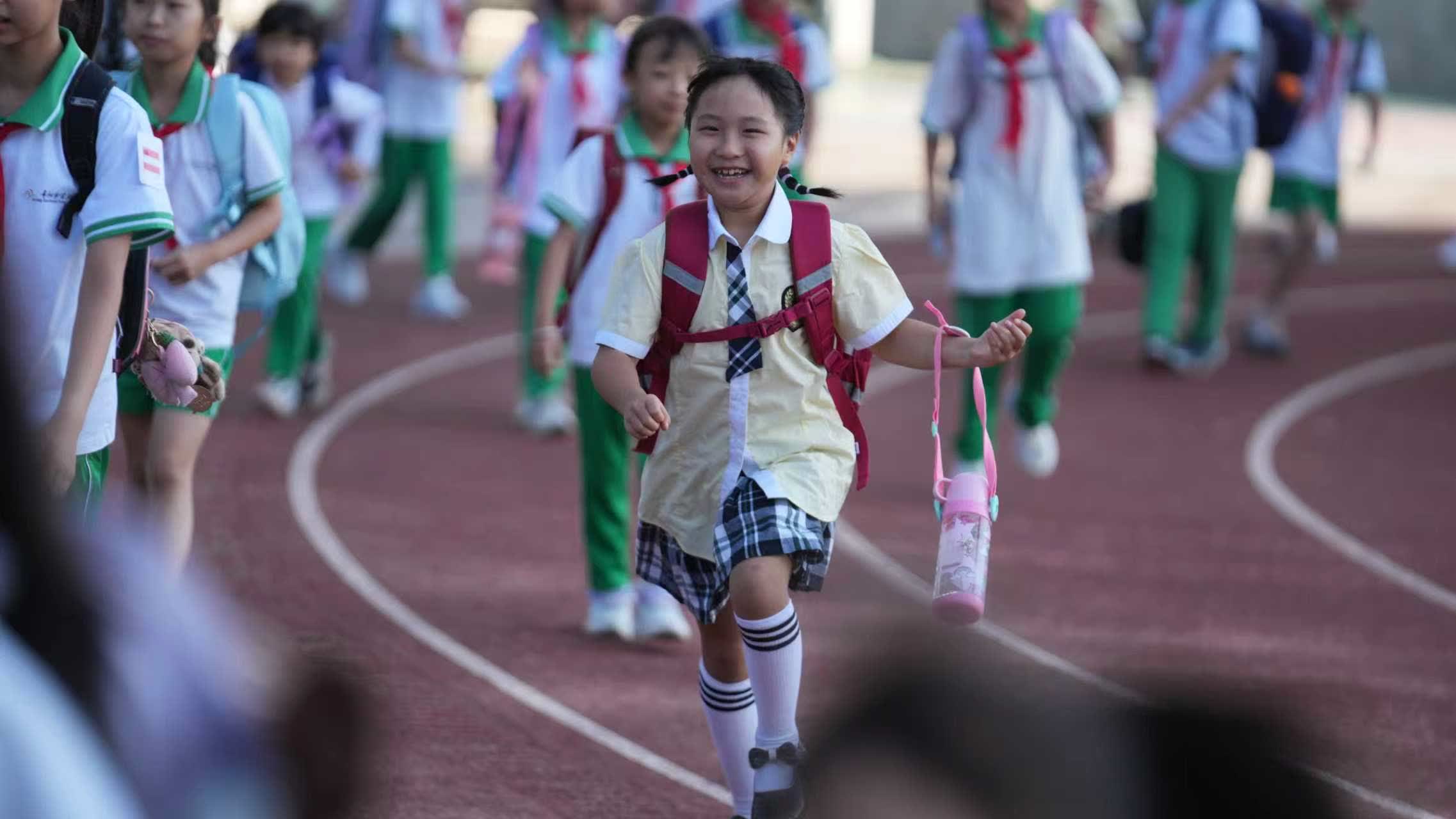 貴陽市實驗小學未來方舟分校的學生笑着跑進校園。（新華社）