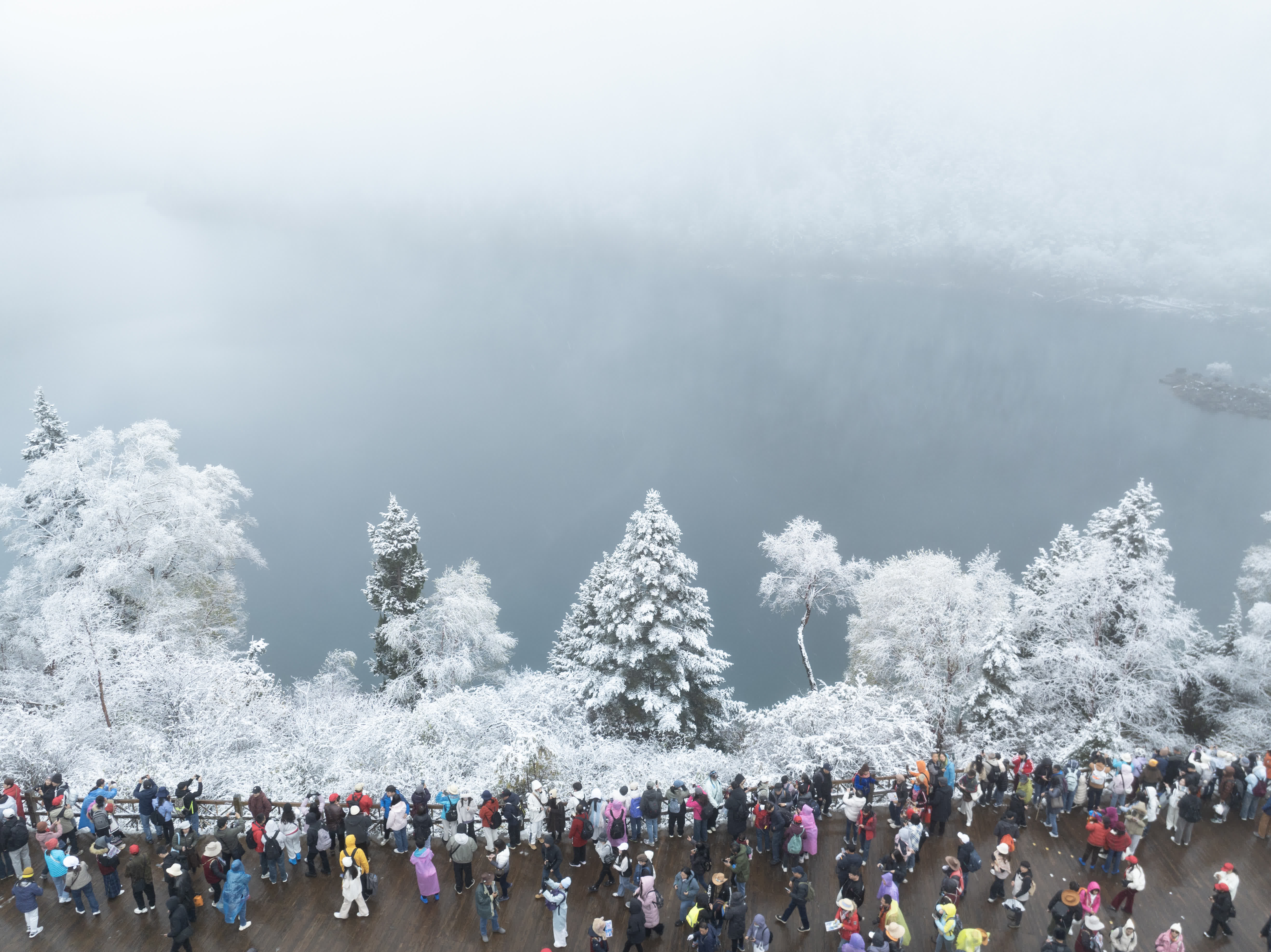 遊客在九寨溝長海欣賞雪景（10月24日攝，無人機照片）。（新華社）