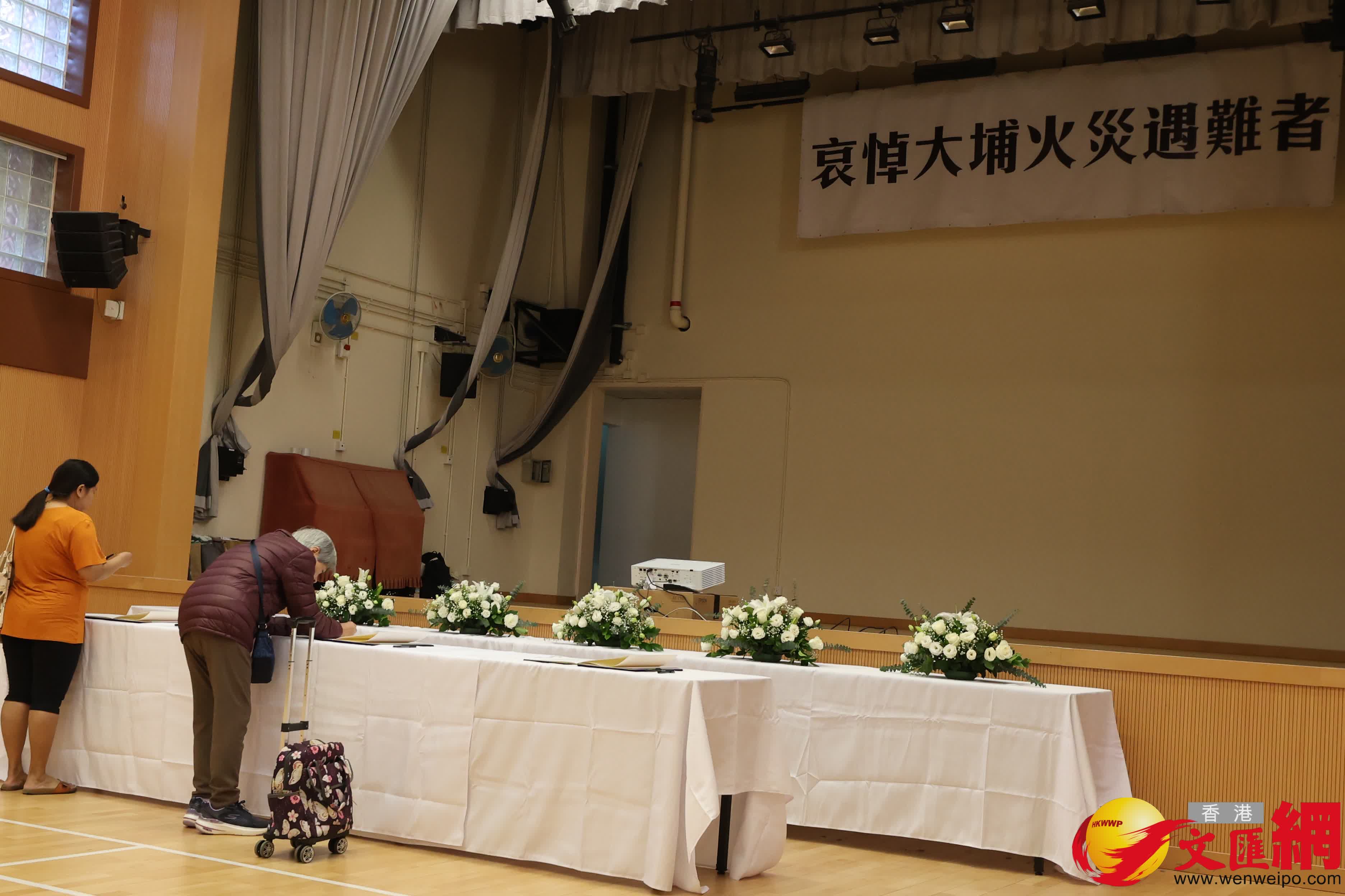 有市民在大埔富亨邨鄰里社區中心內設置的弔唁冊上，寫下罹難者的深切悼念和對受災居民的關懷祝願。（香港文匯報記者萬霜靈攝）