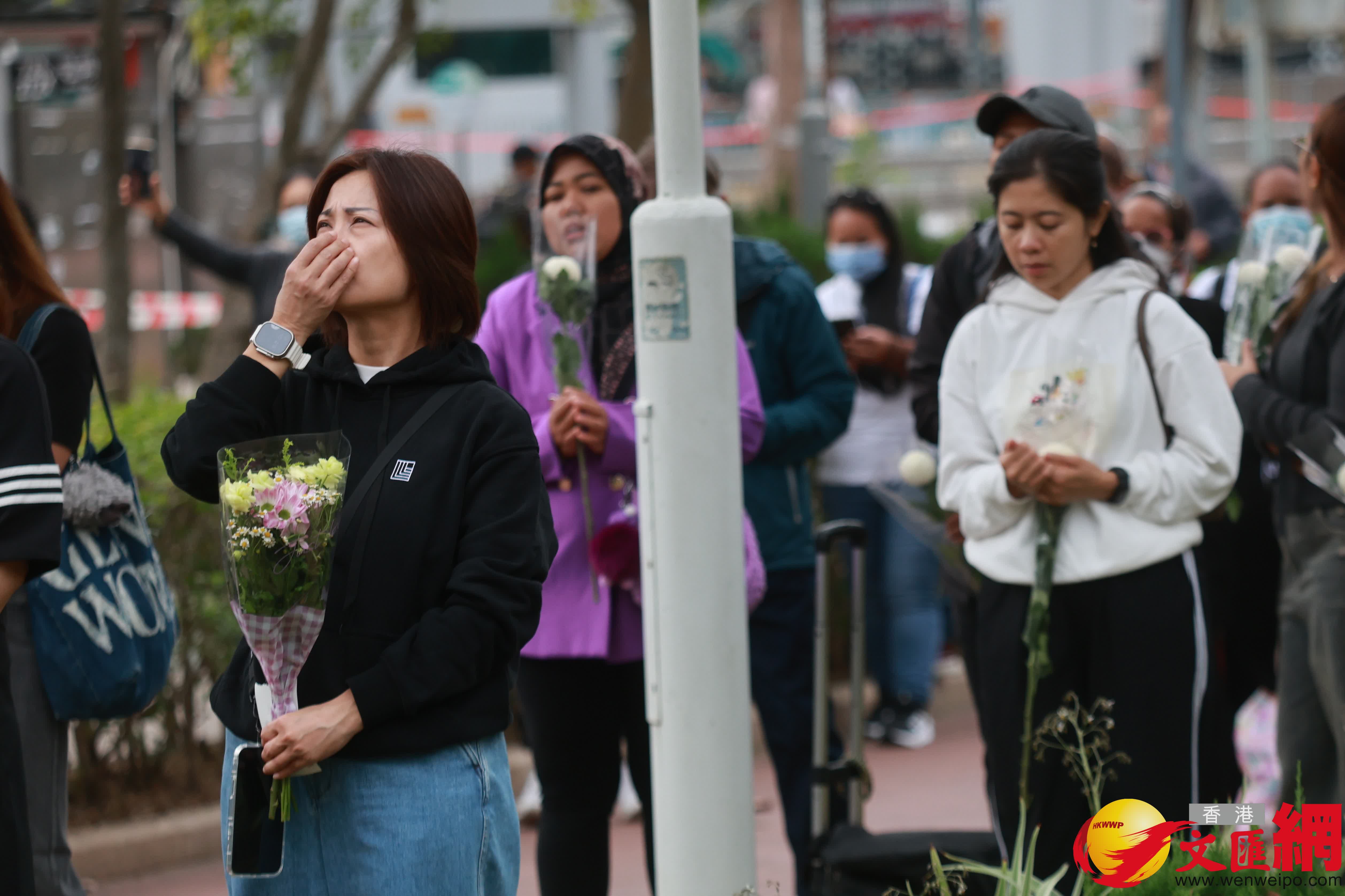 市民到大埔宏福苑火災現場獻花，部分市民神情哀傷。（香港文匯報記者 北山彥 攝）