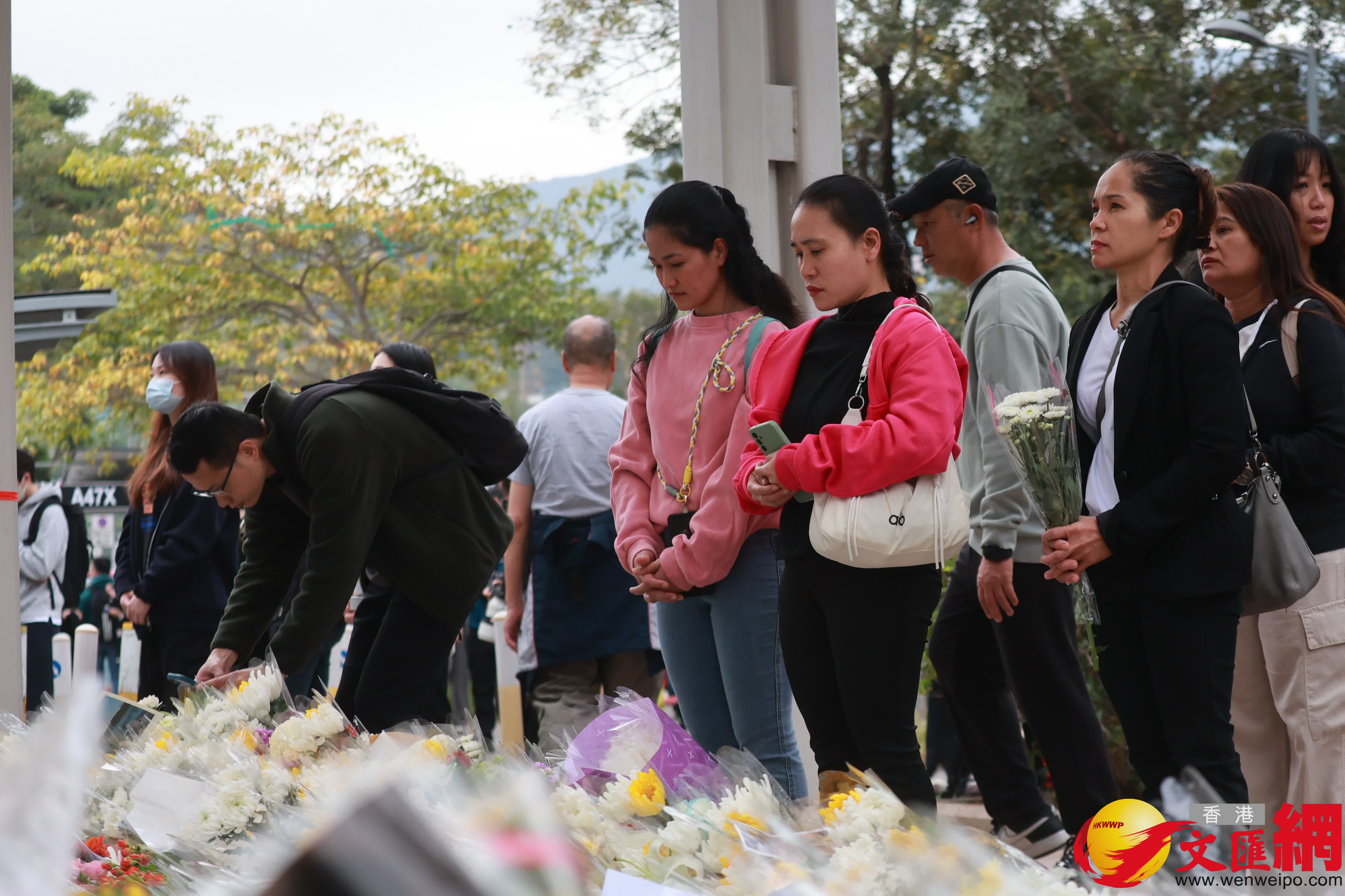 市民到大埔宏福苑火災現場獻花，部分市民神情哀傷。（香港文匯報記者 北山彥 攝）