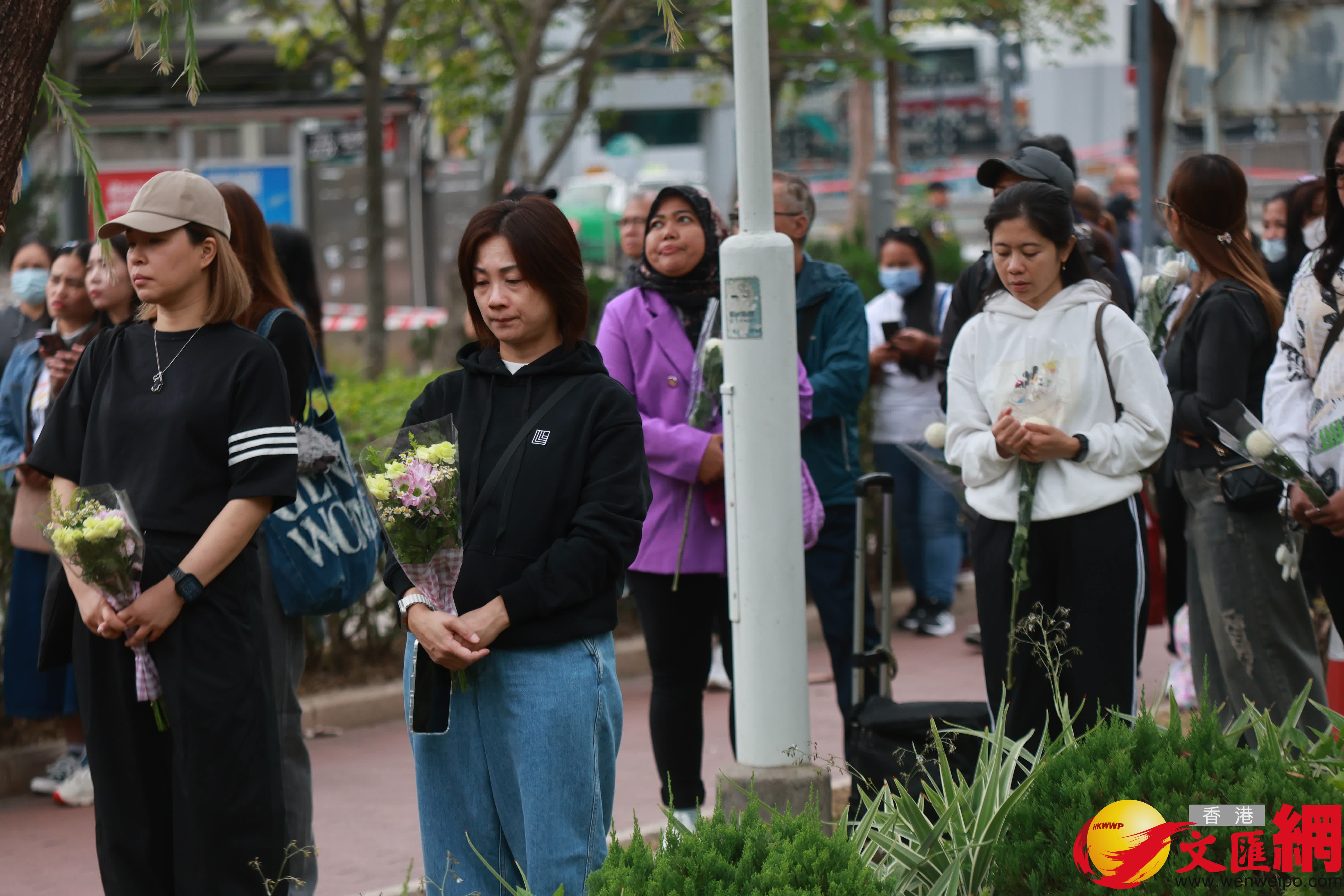 市民到大埔宏福苑火災現場獻花，部分市民神情哀傷。（香港文匯報記者 北山彥 攝）