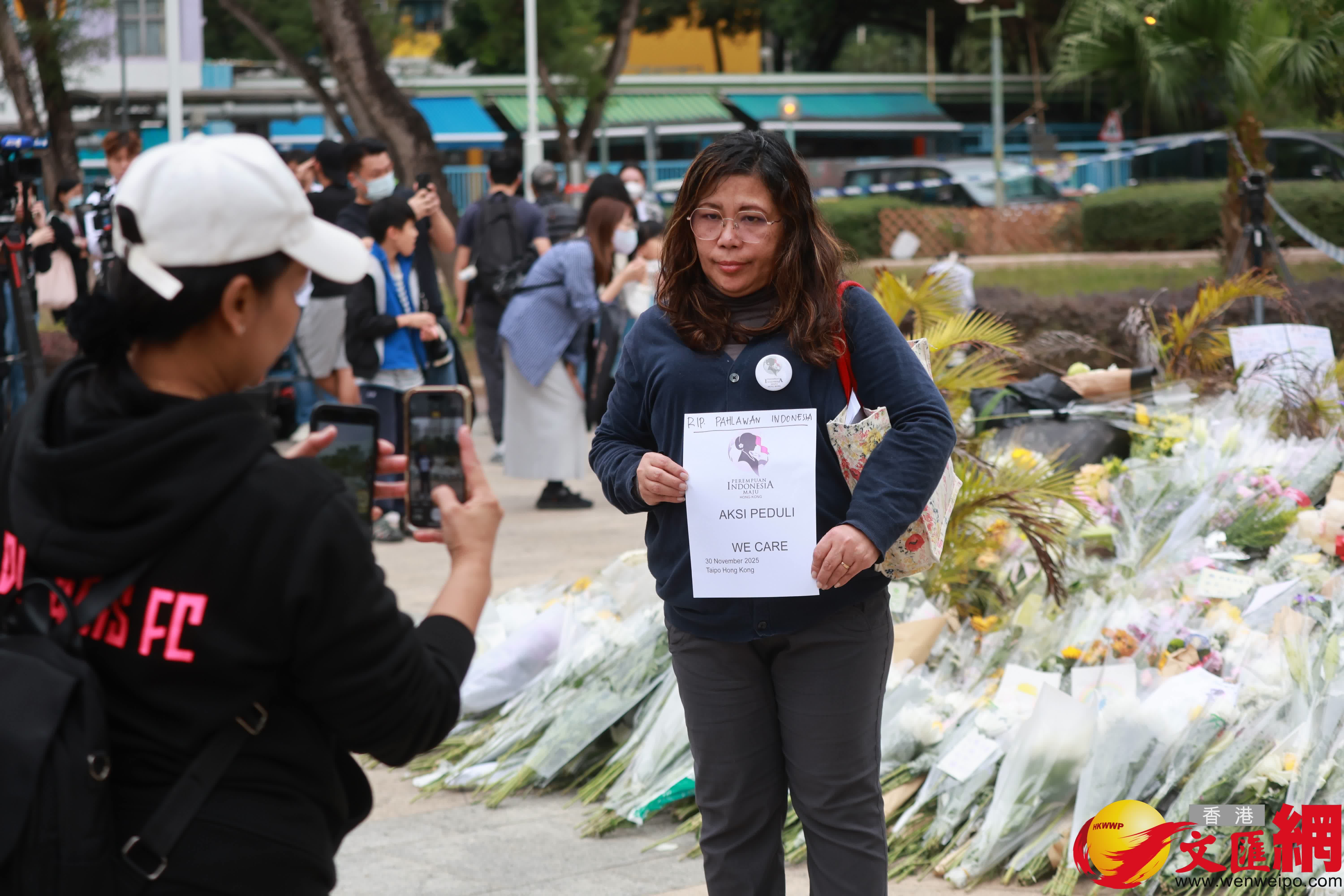 市民到大埔宏福苑火災現場獻花，部分市民神情哀傷。（香港文匯報記者 北山彥 攝）