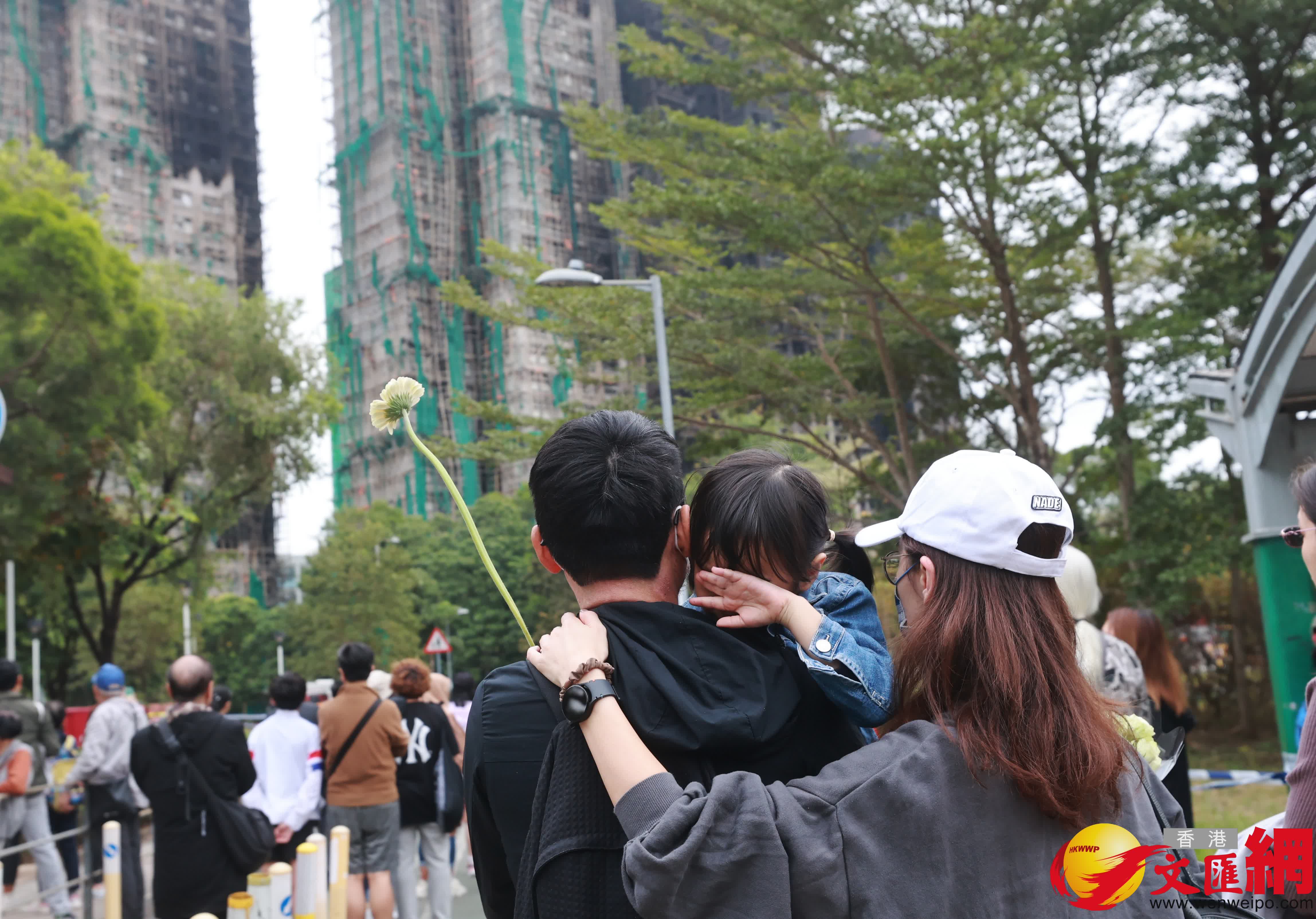 市民到大埔宏福苑火災現場獻花，部分市民神情哀傷。（香港文匯報記者 北山彥 攝）
