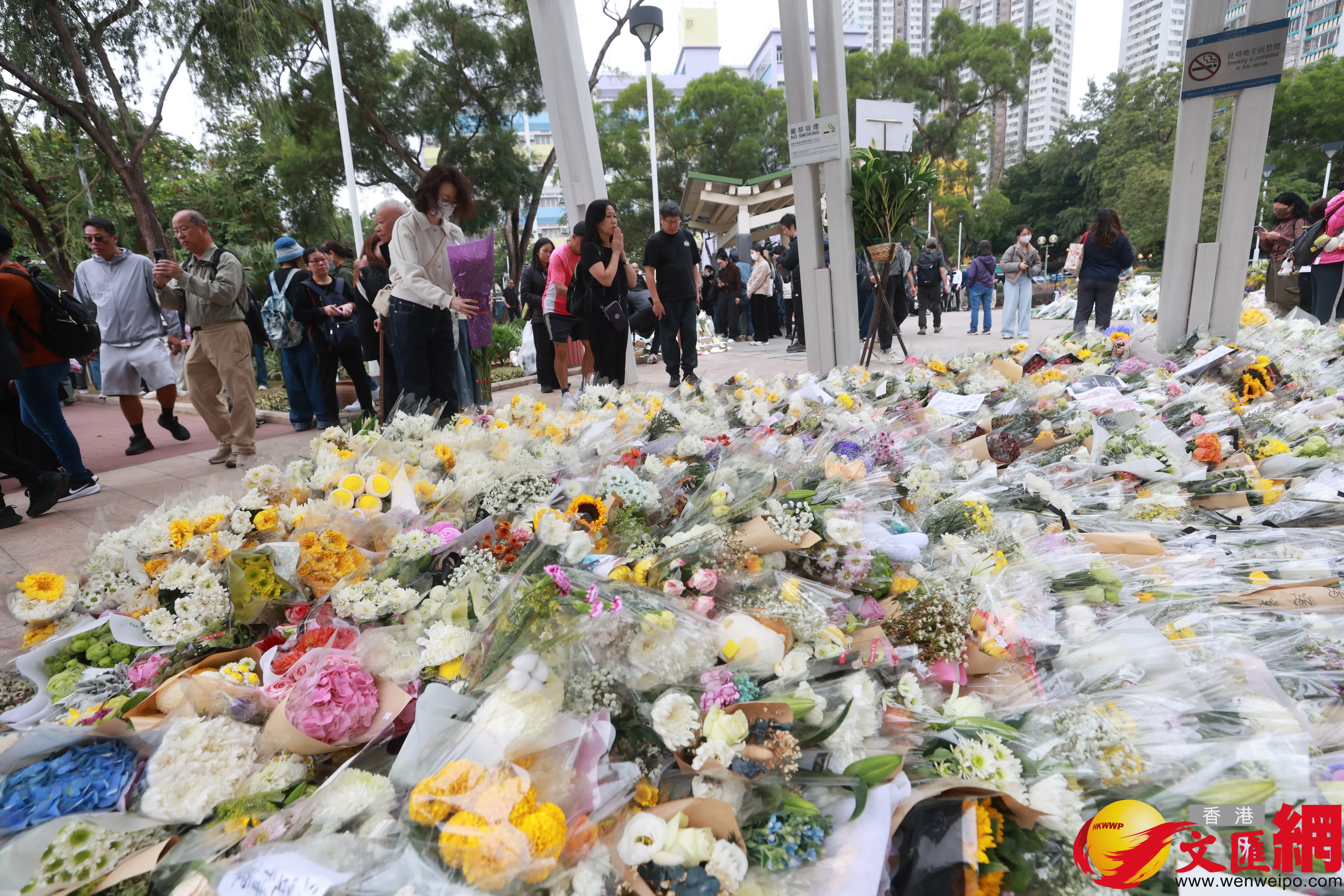 市民到大埔宏福苑火災現場獻花，部分市民神情哀傷。（香港文匯報記者 北山彥 攝）