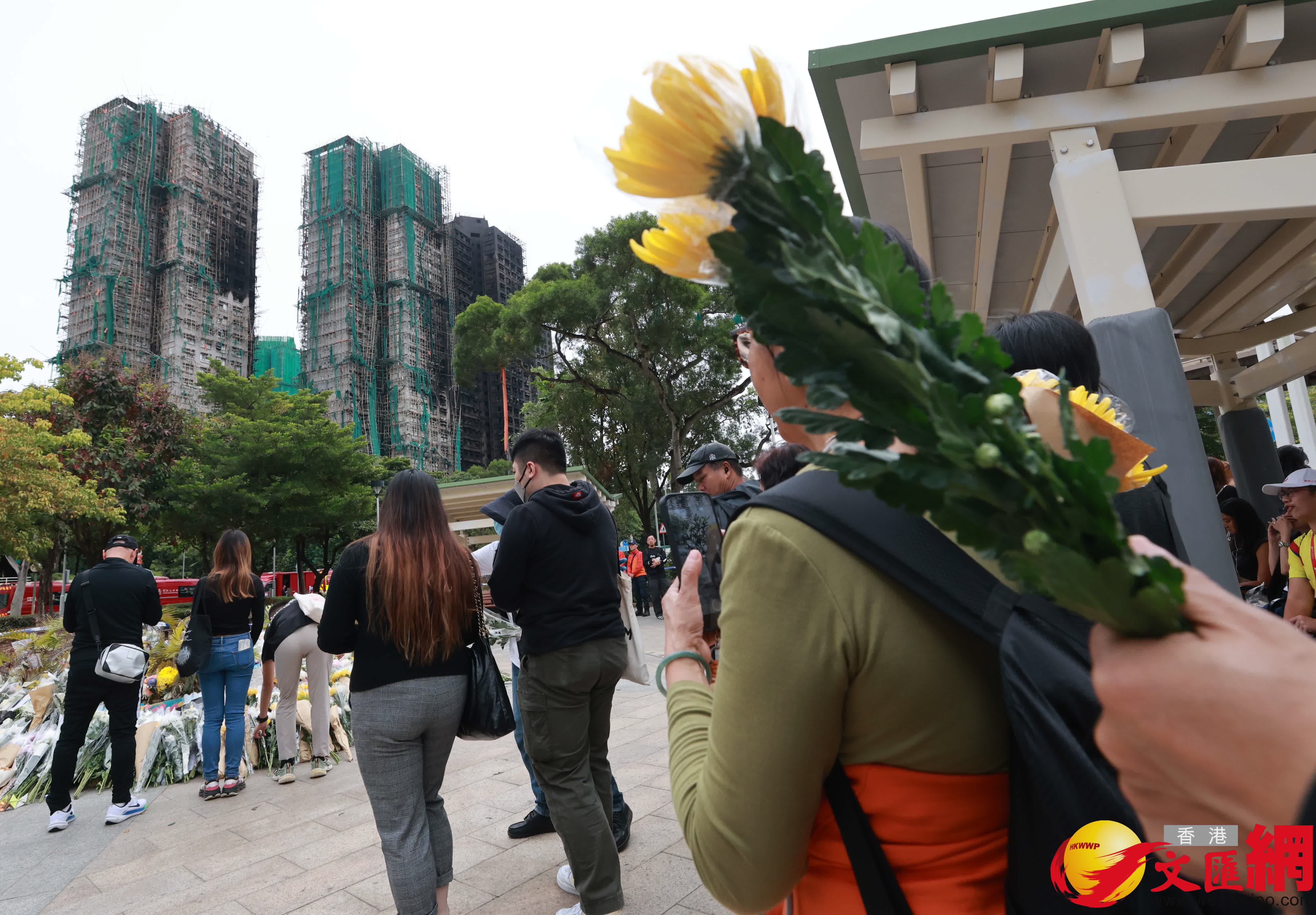 市民到大埔宏福苑火災現場獻花，部分市民神情哀傷。（香港文匯報記者 北山彥 攝）