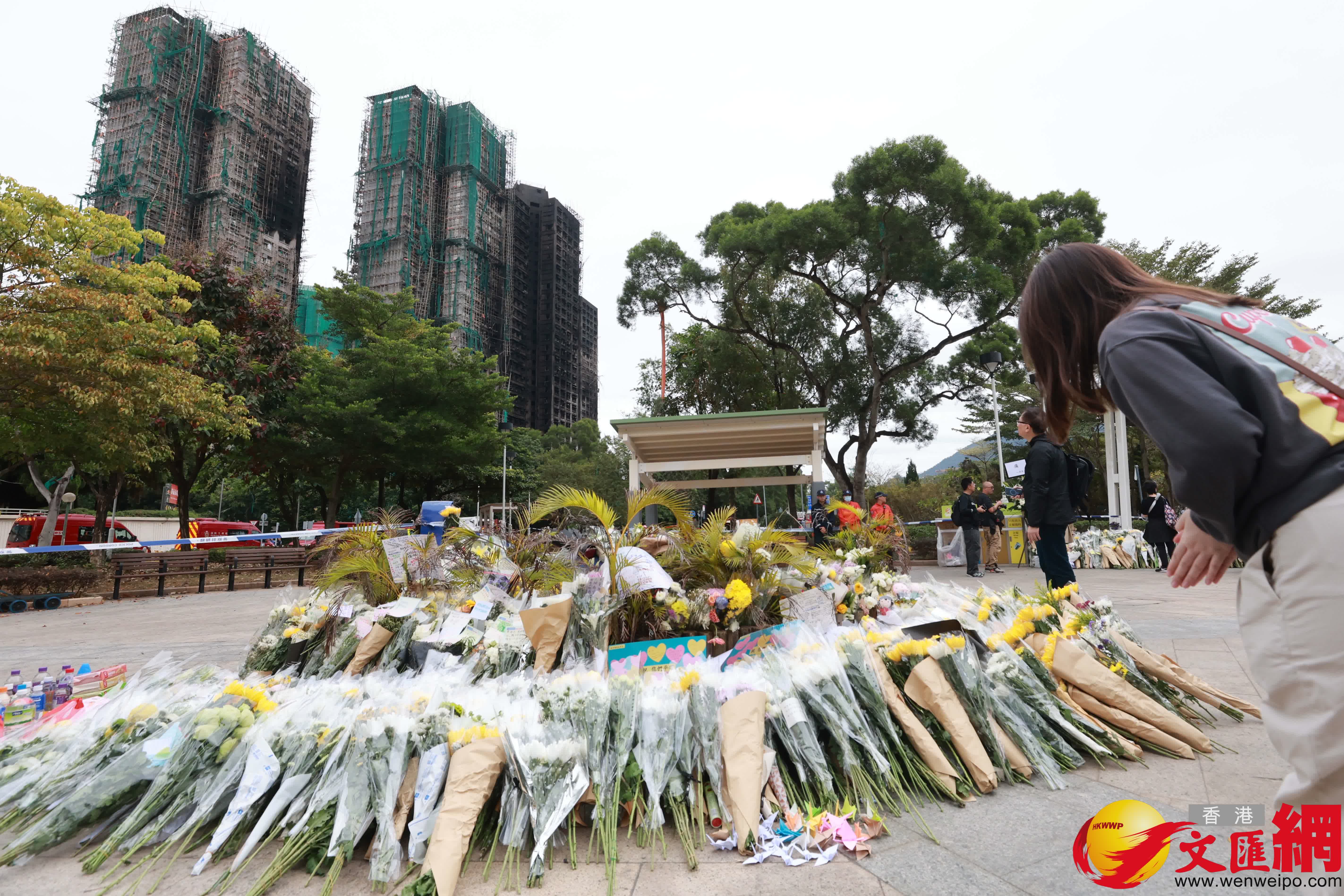 市民到大埔宏福苑火災現場獻花，部分市民神情哀傷。（香港文匯報記者 北山彥 攝）