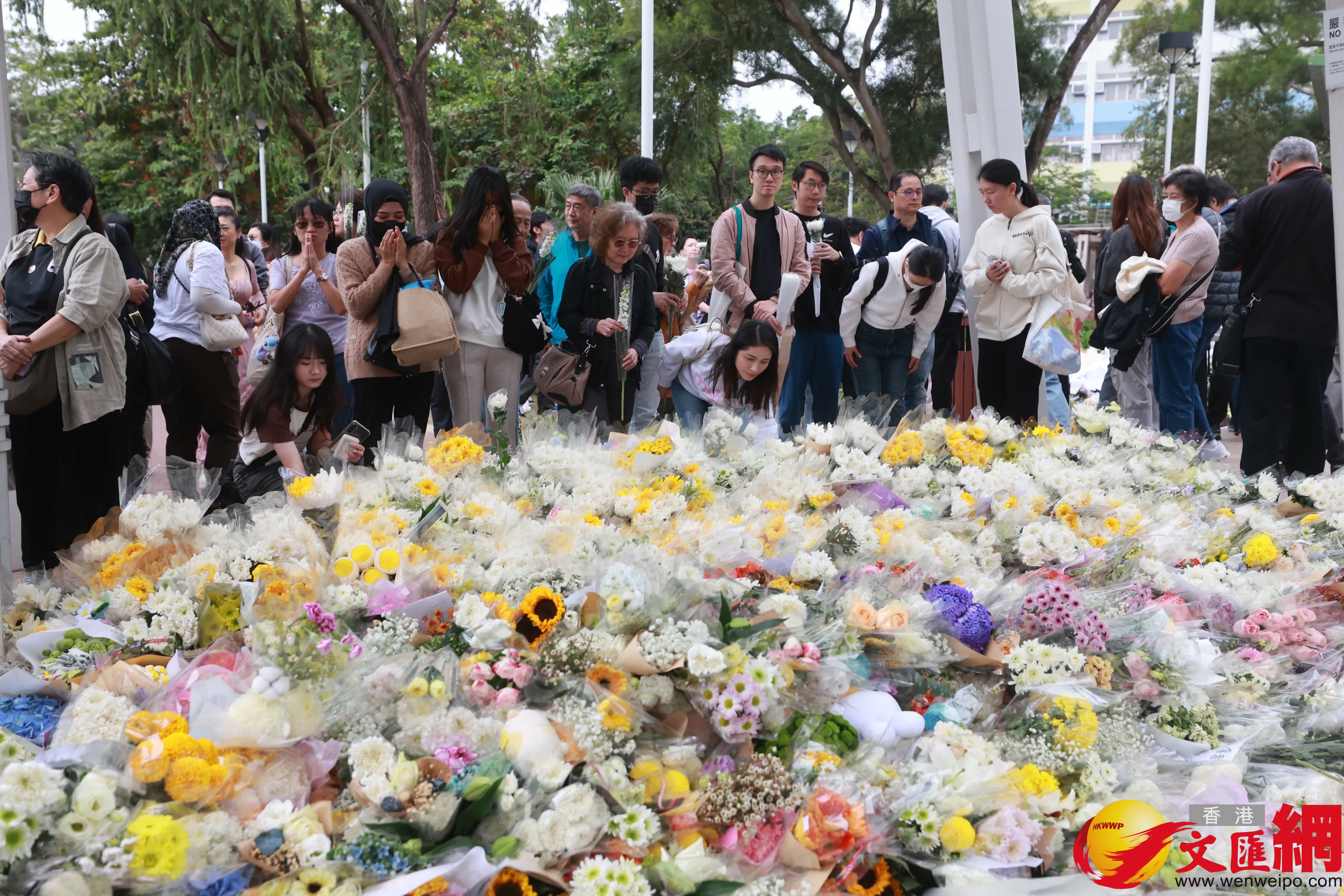 市民到大埔宏福苑火災現場獻花，部分市民神情哀傷。（香港文匯報記者 北山彥 攝）