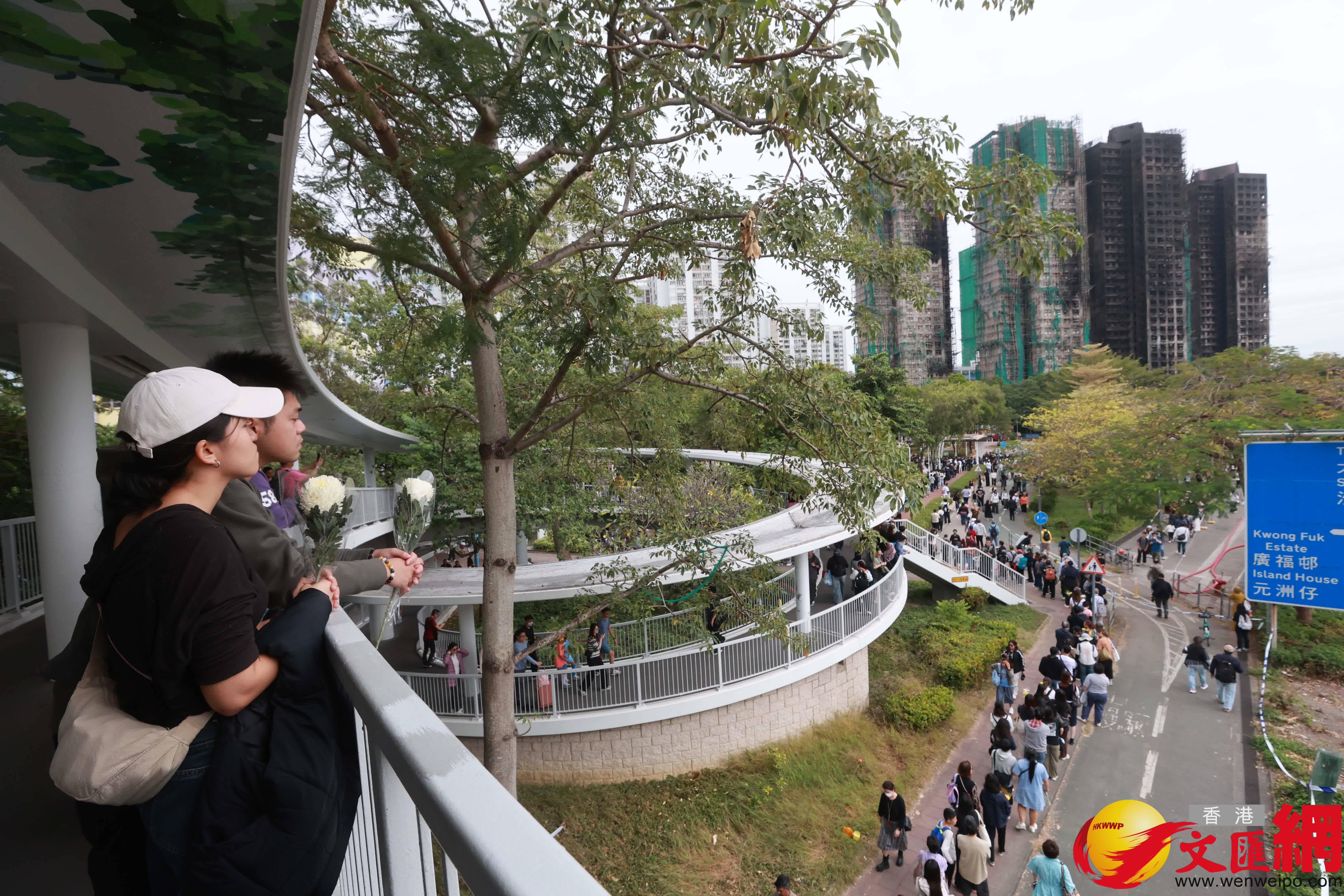市民到大埔宏福苑火災現場獻花，部分市民神情哀傷。（香港文匯報記者 北山彥 攝）