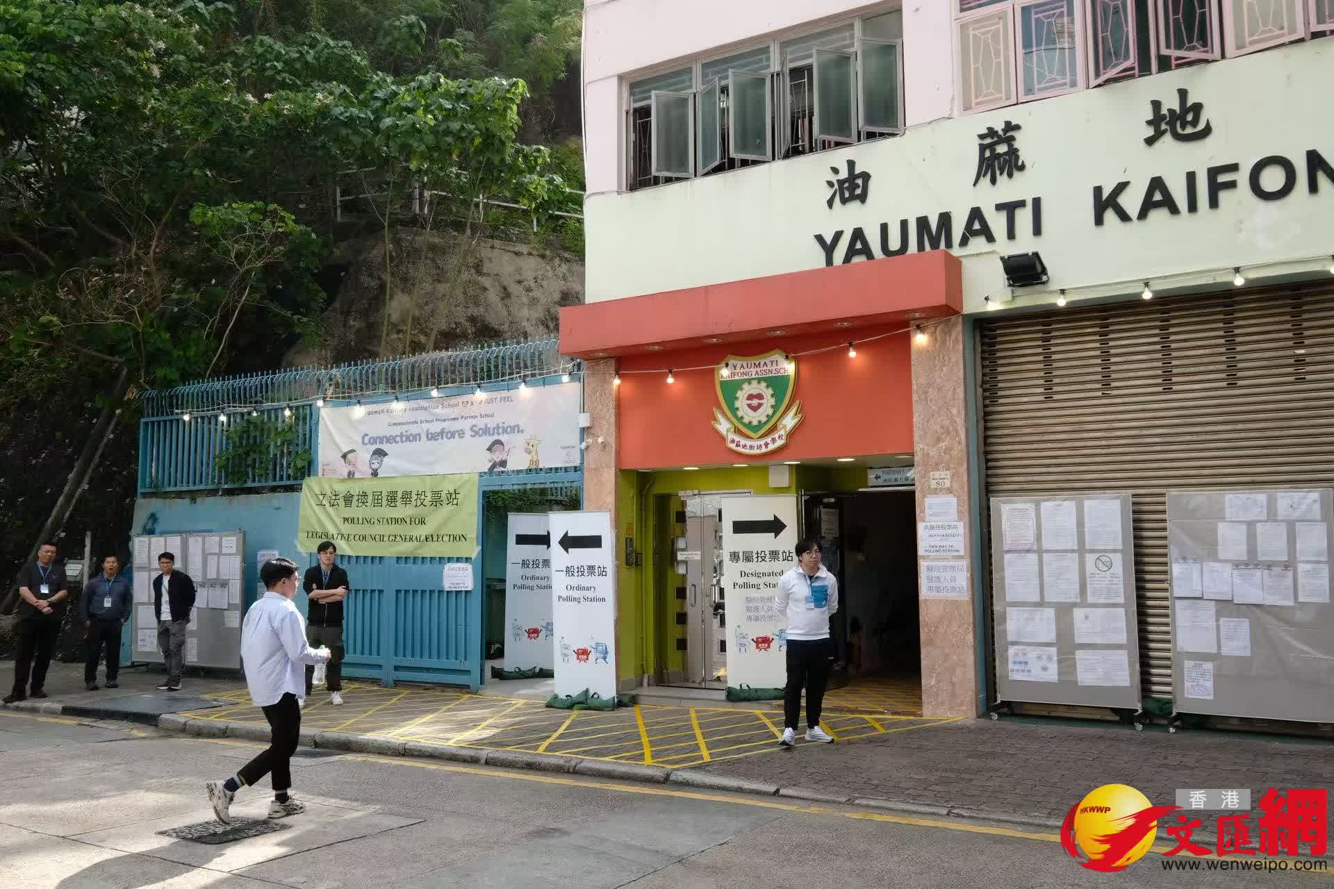 油麻地街坊會學校專屬票站運作順暢，有市民投完票後於門外打卡拍照留念。（香港文匯報記者涂穴攝）