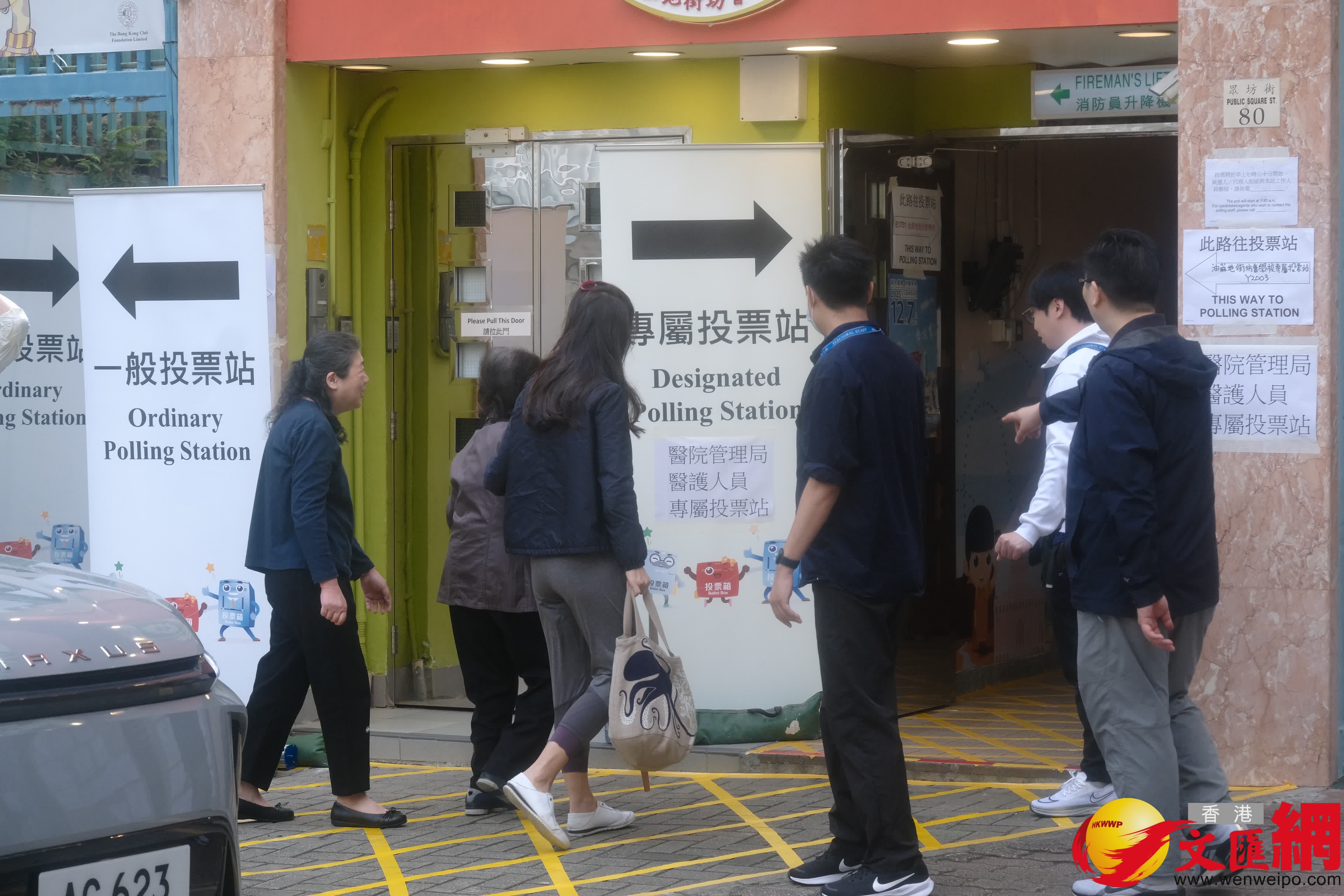 油麻地街坊會學校專屬票站運作順暢，有市民投完票後於門外打卡拍照留念。（香港文匯報記者涂穴攝）
