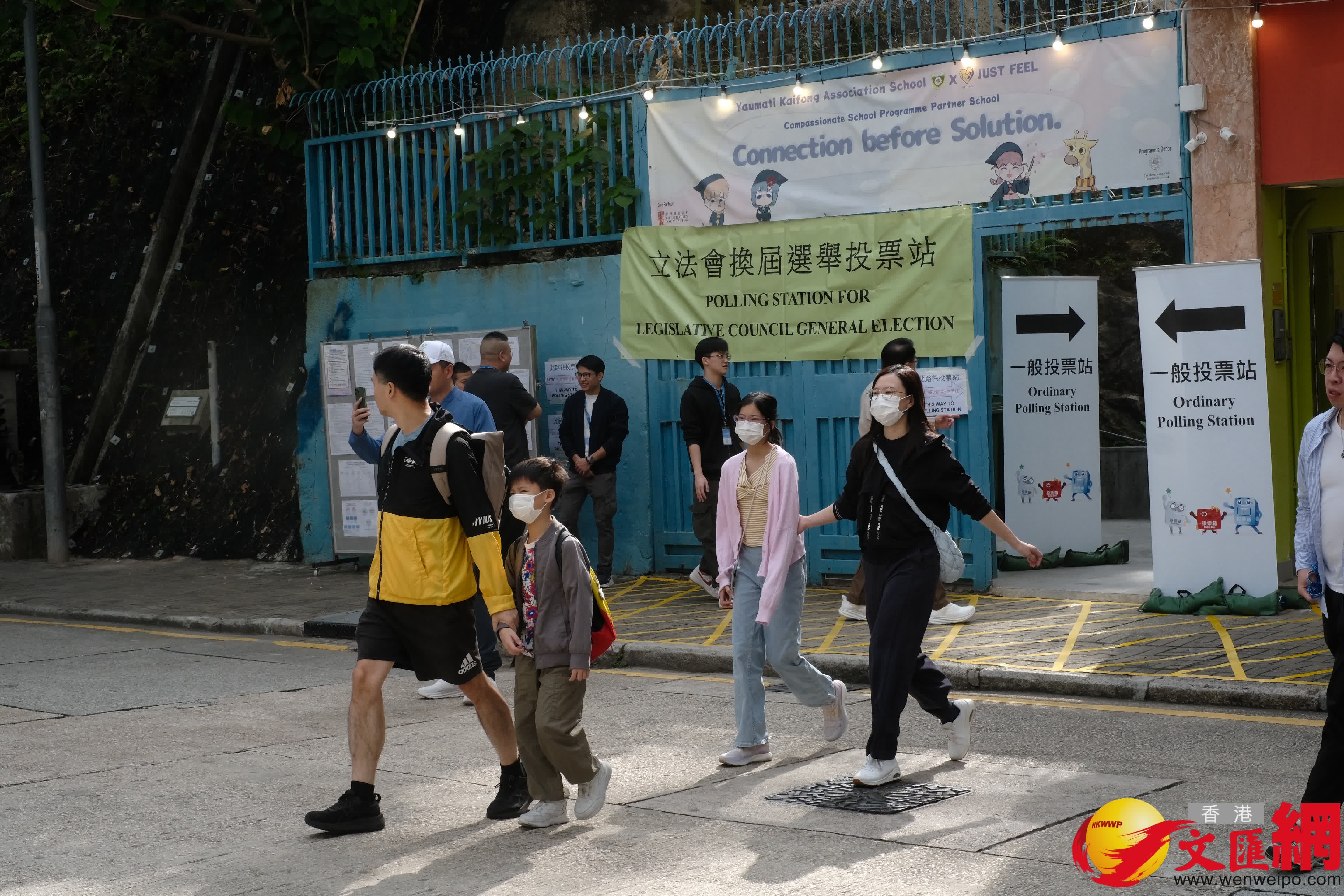 油麻地街坊會學校專屬票站運作順暢，有市民投完票後於門外打卡拍照留念。（香港文匯報記者涂穴攝）