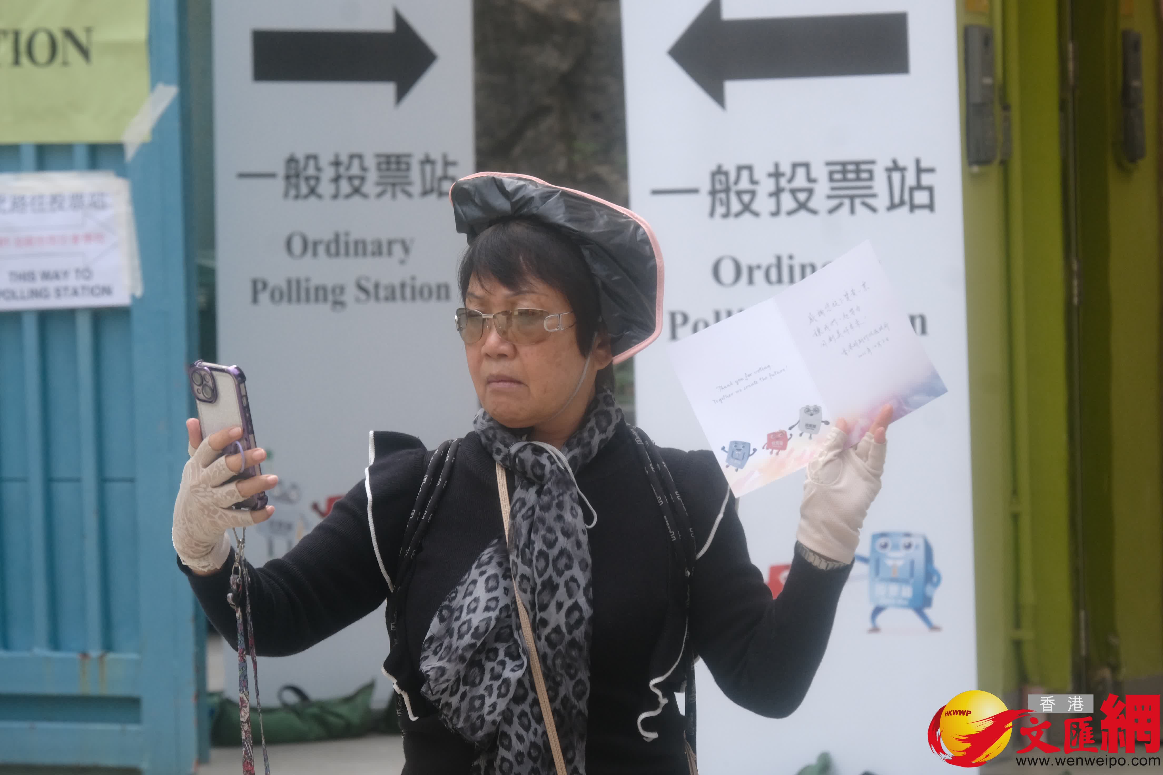 油麻地街坊會學校專屬票站運作順暢，有市民投完票後於門外打卡拍照留念。（香港文匯報記者涂穴攝）