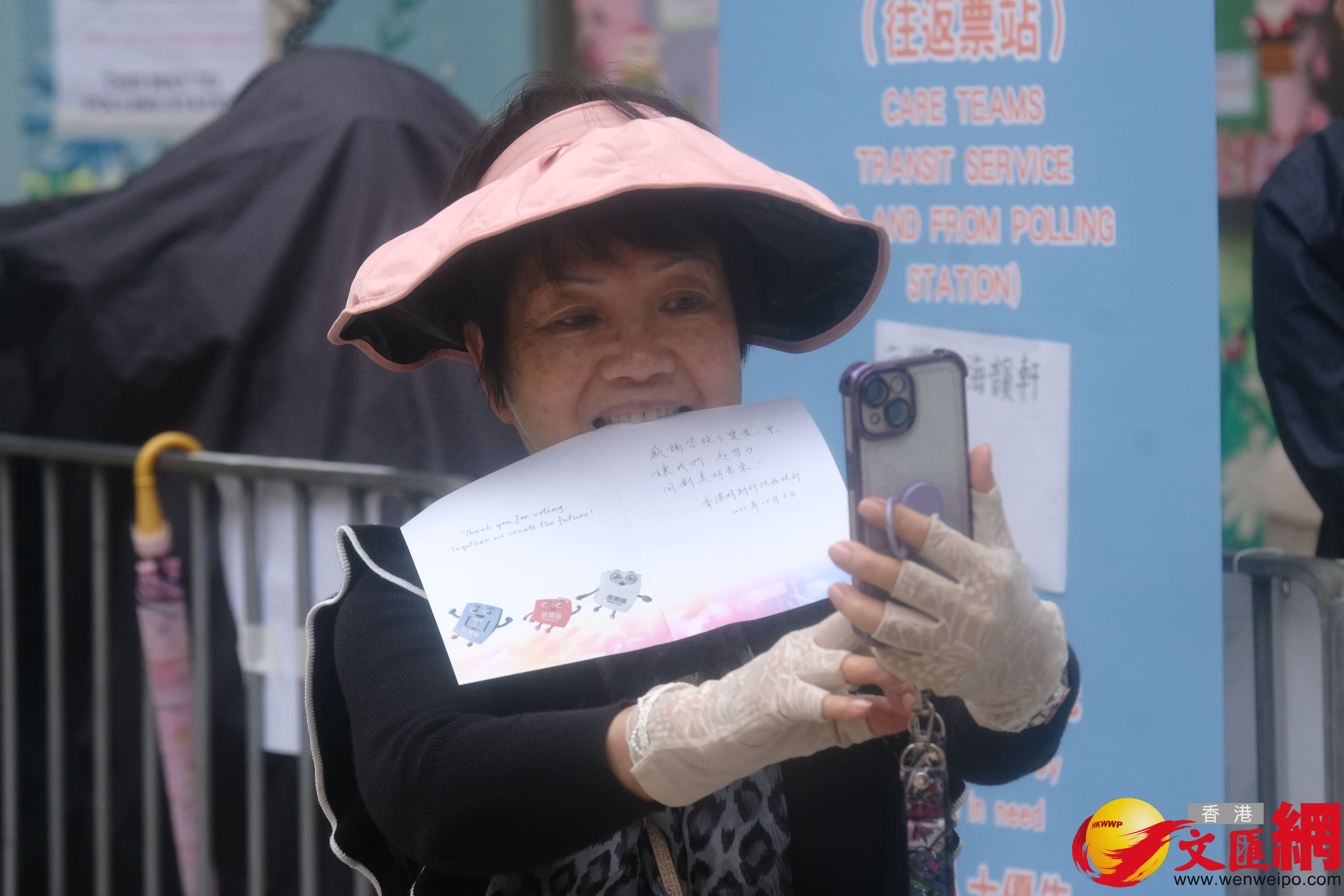 油麻地街坊會學校專屬票站運作順暢，有市民投完票後於門外打卡拍照留念。（香港文匯報記者涂穴攝）