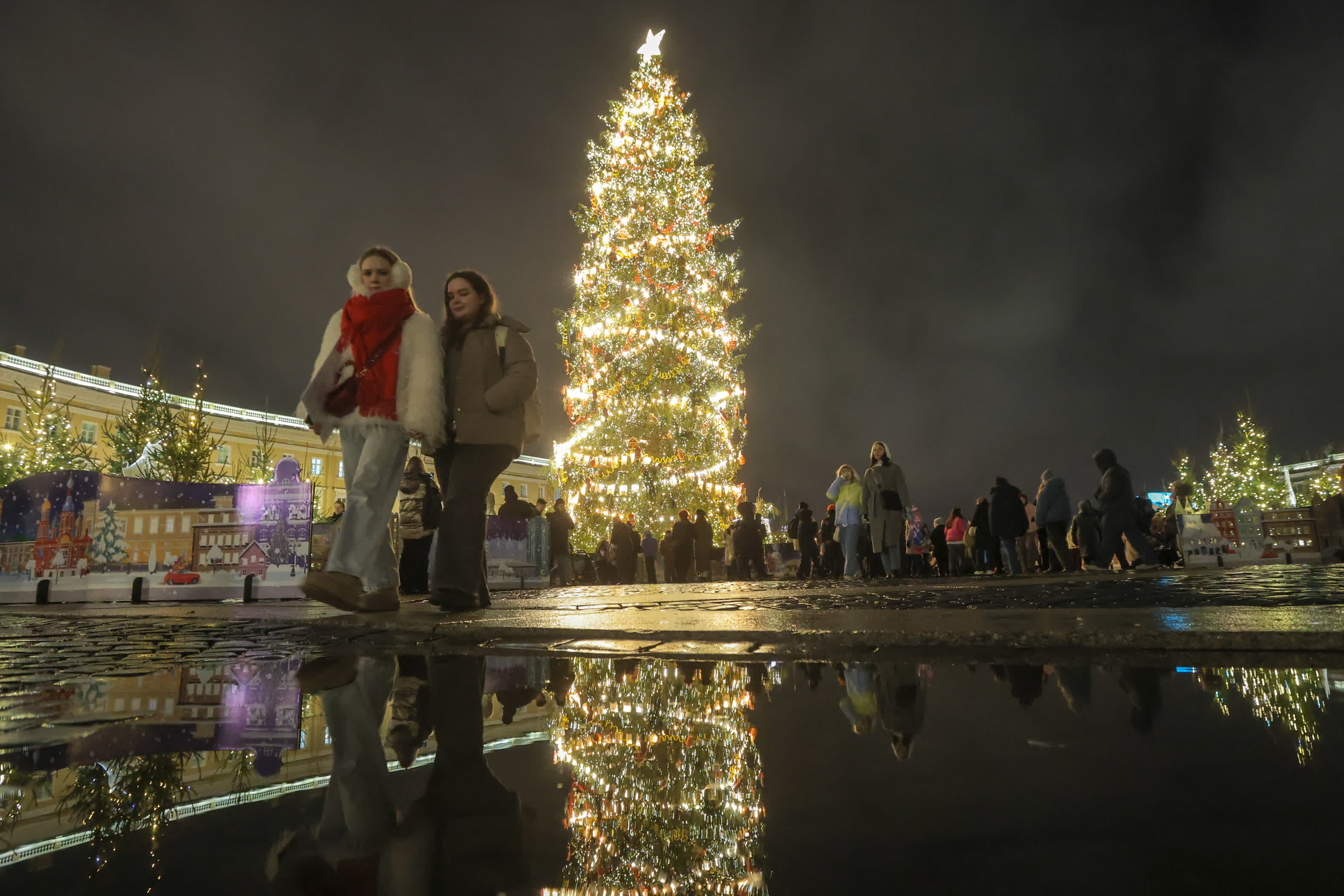 12月20日，在俄羅斯聖彼得堡，行人經過新年樹。新華社