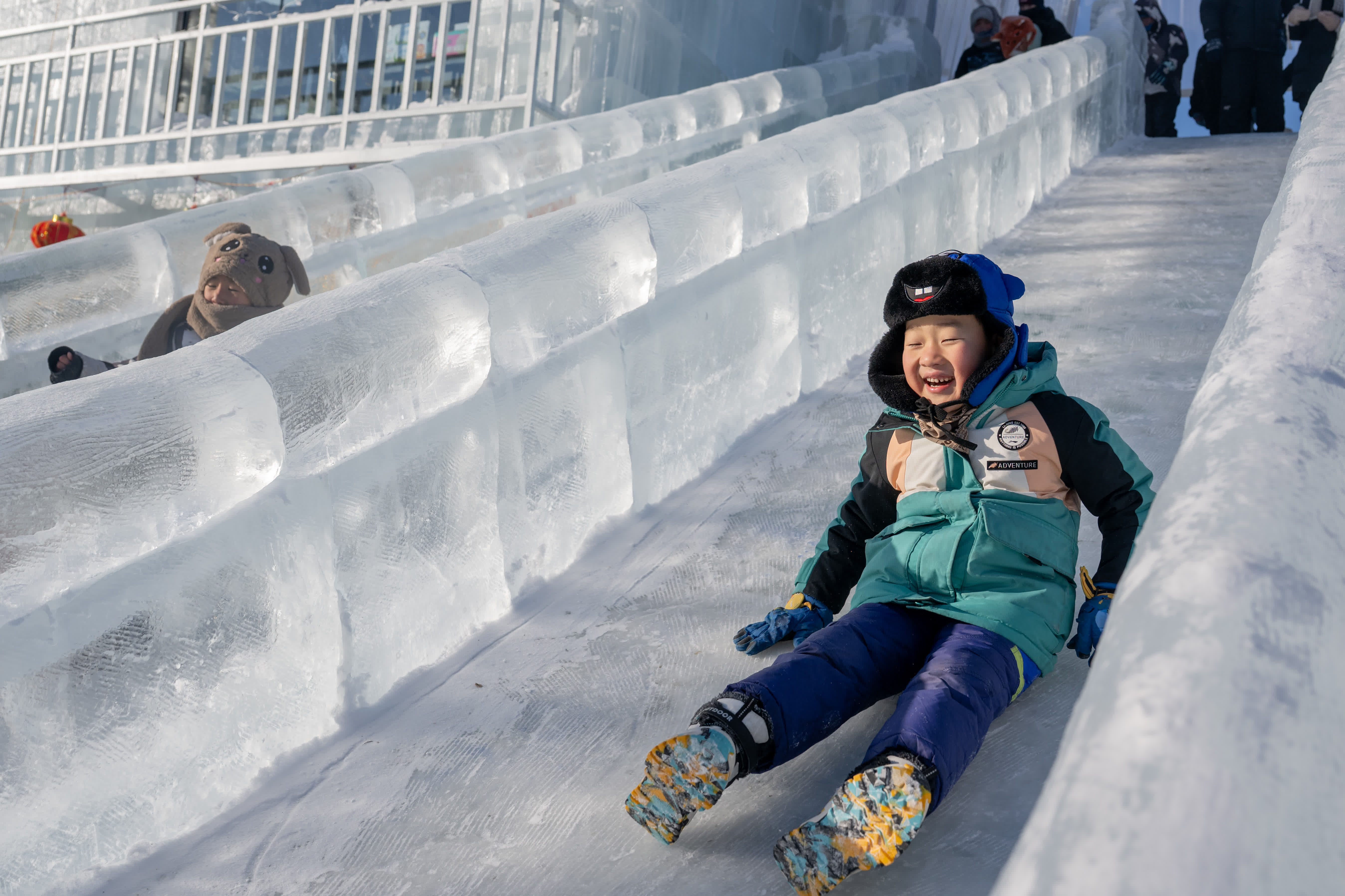 12月21日，孩子們在冰雪那達慕開幕式上滑冰梯。（新華社）