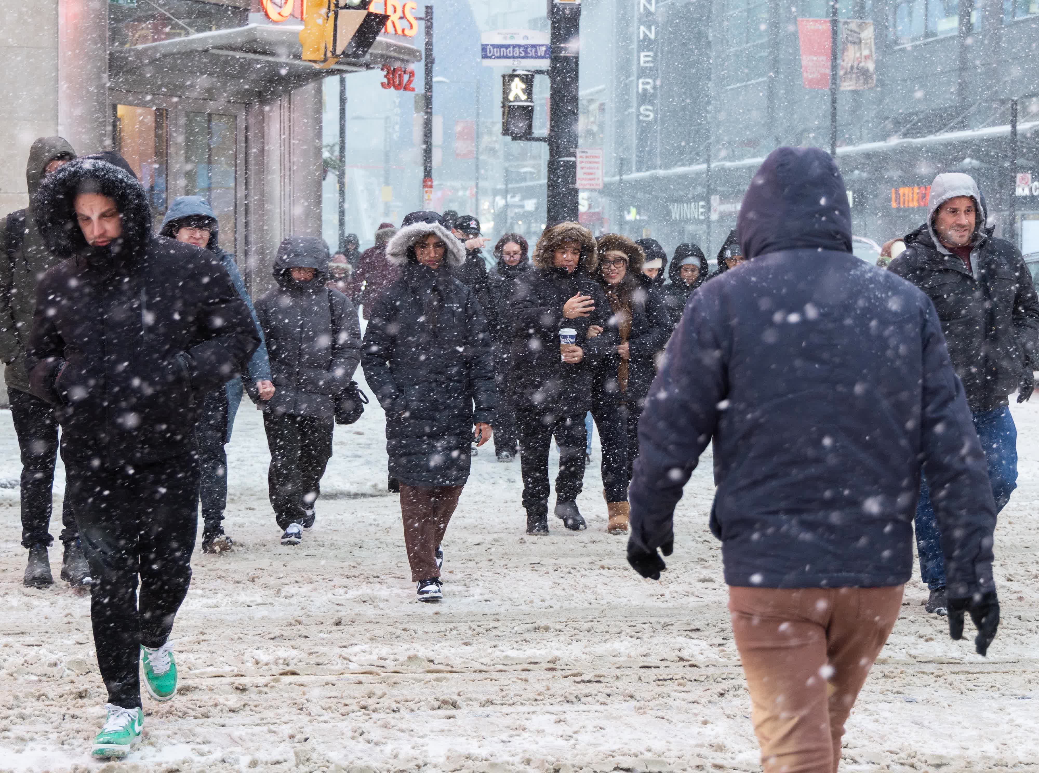 12月26日，在加拿大多倫多，人們在風雪中出行。（新華社）