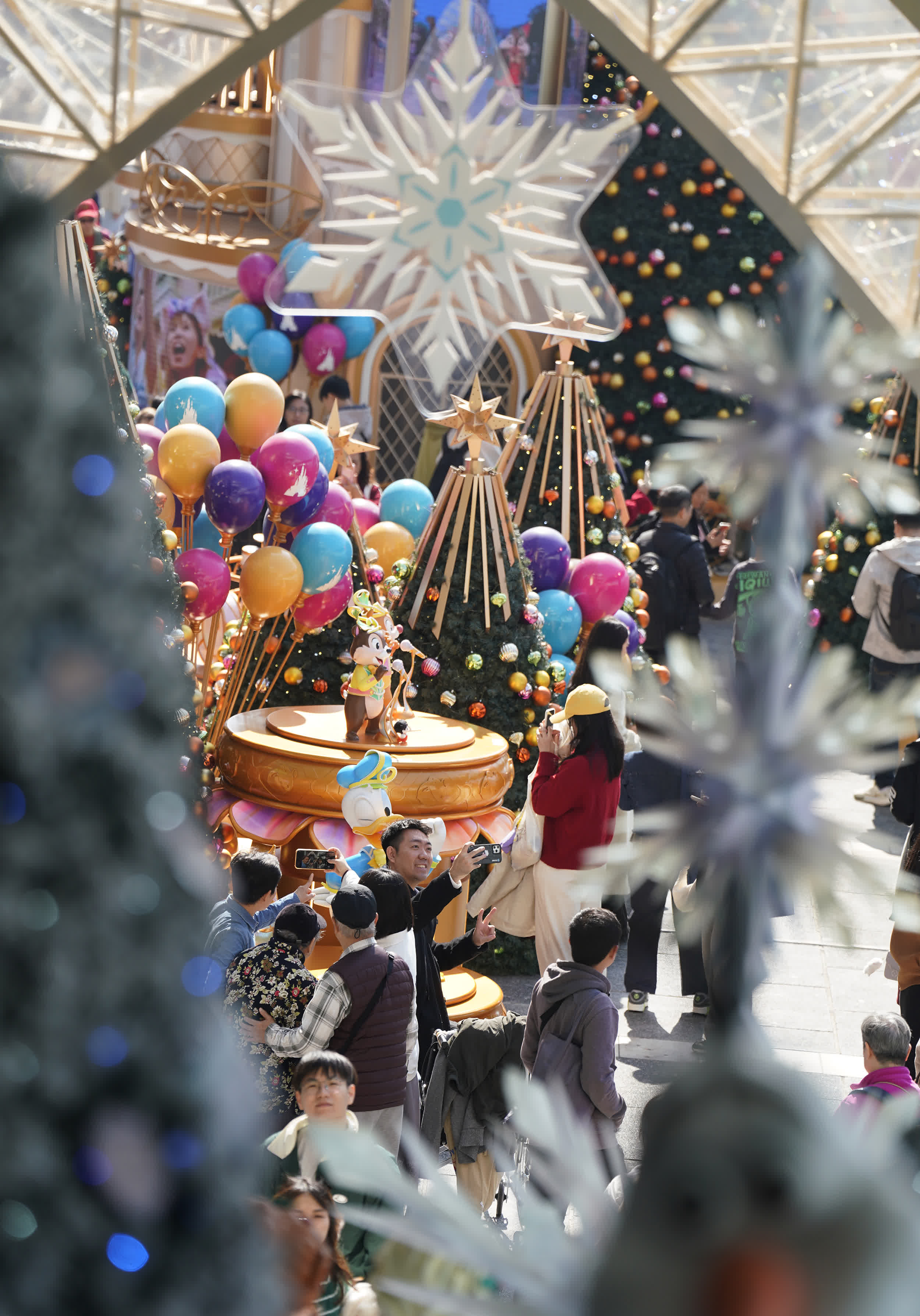 圖為遊客與市民在海港城聖誕裝飾前拍照打卡。（香港中通社）