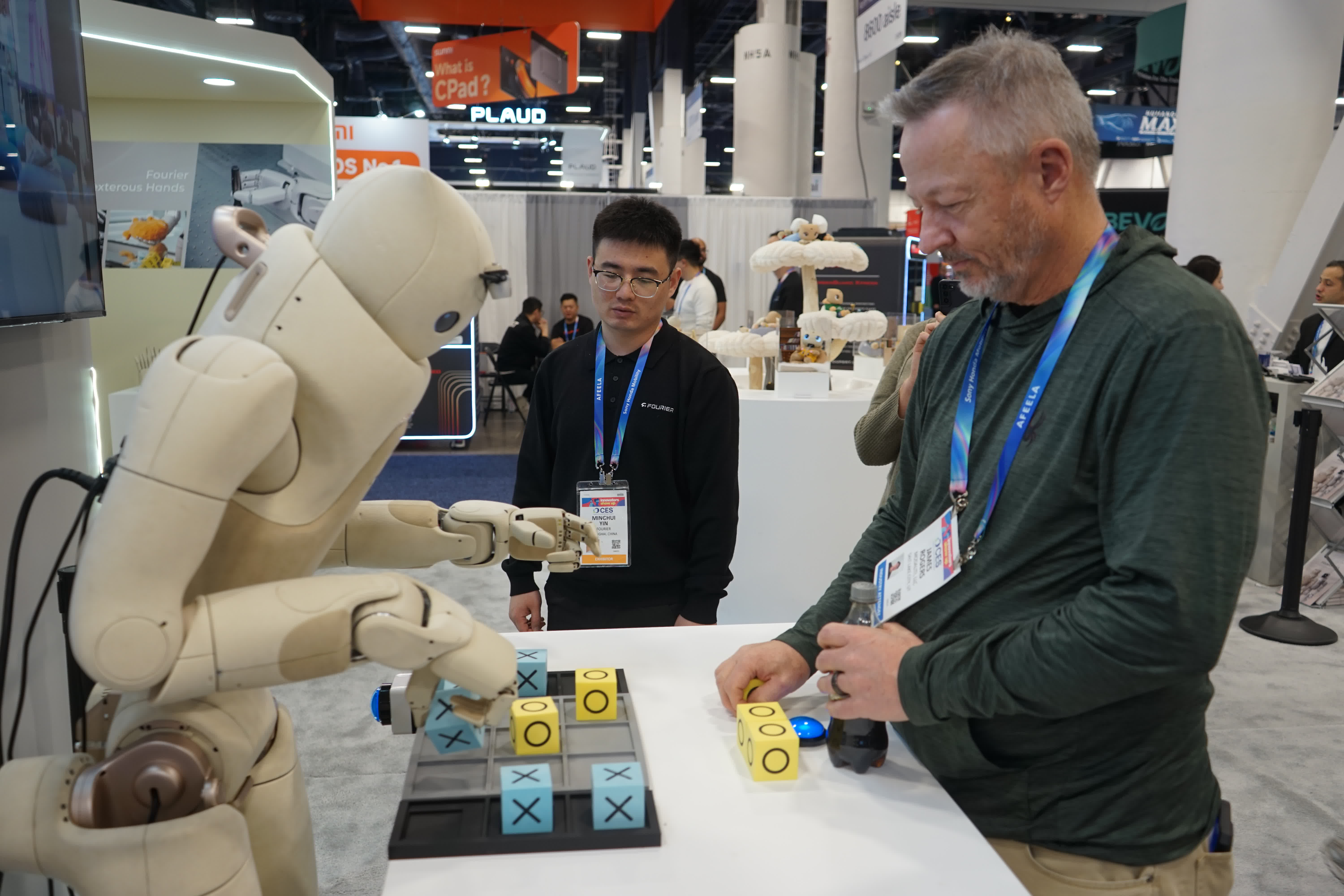 1月8日，在美國拉斯維加斯消費電子展上，一名參觀者與傅利葉展區的機器人互動。（新華社）