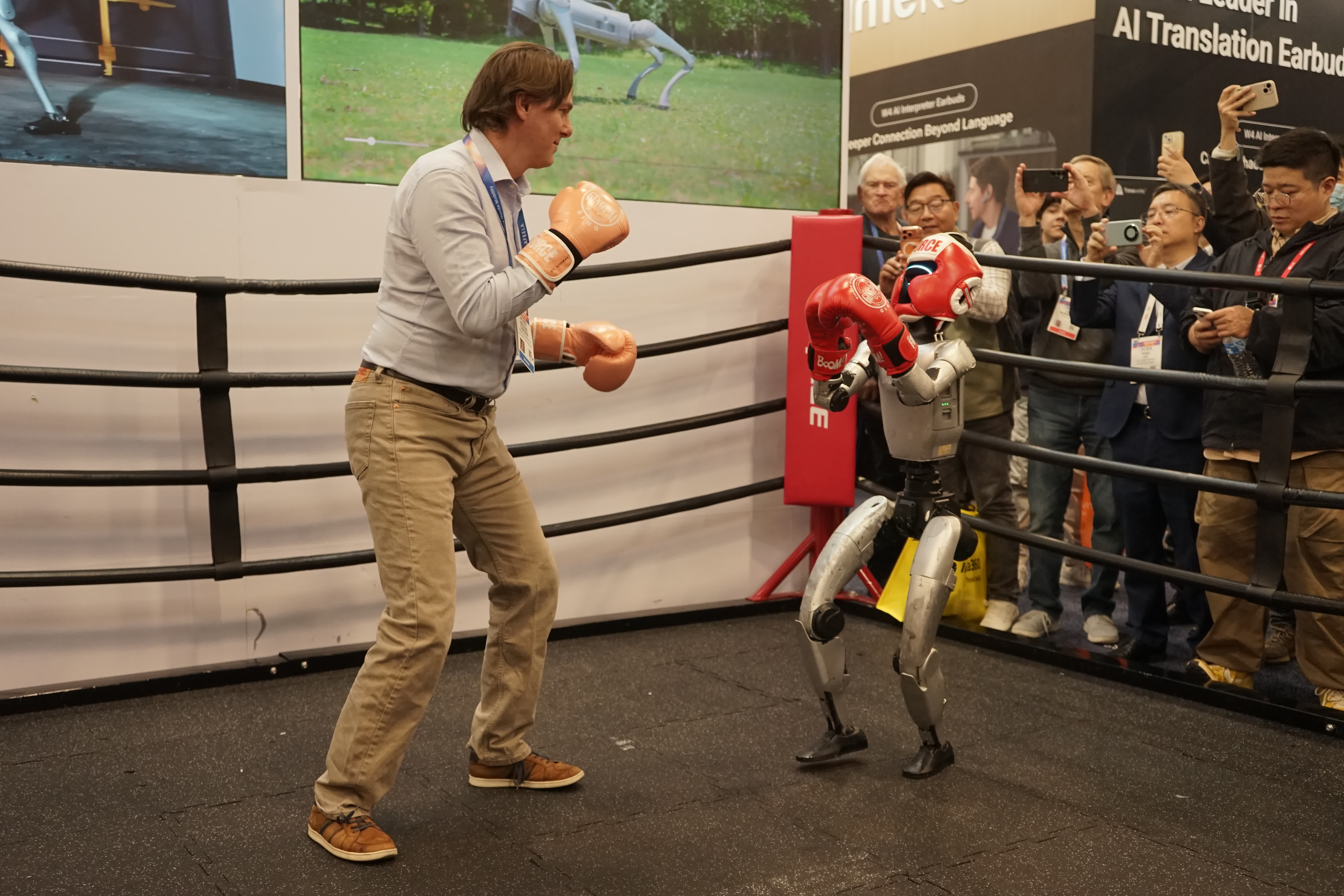 1月8日，在美國拉斯維加斯消費電子展上，一名參觀者與宇樹科技人形機器人互動。（新華社）