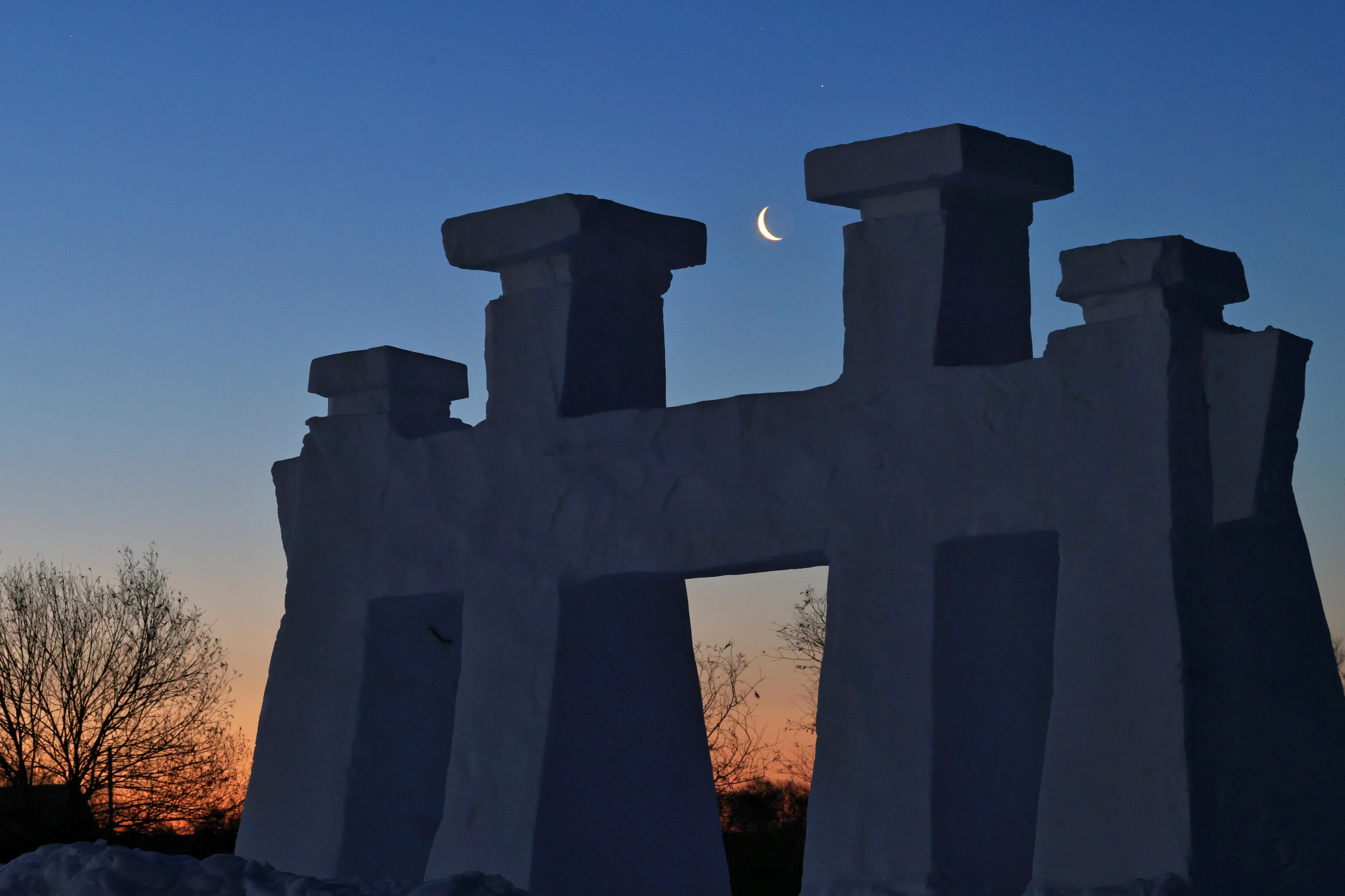 1月15日在黑龍江省同江市拍攝的月亮與雪雕。（新華社）