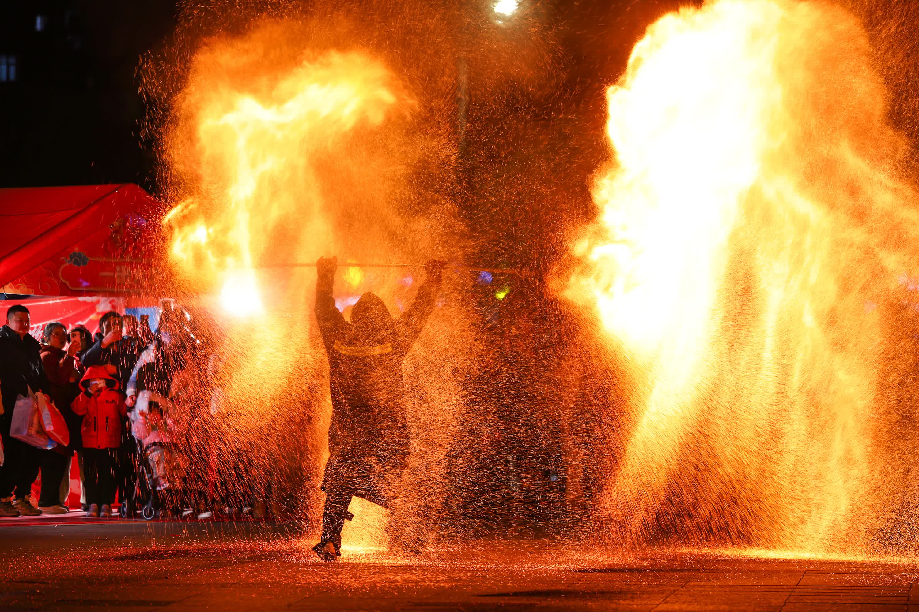 2月9日晚，家長和小朋友在江蘇省海安市星湖001商業廣場觀看火壺表演。（新華社）