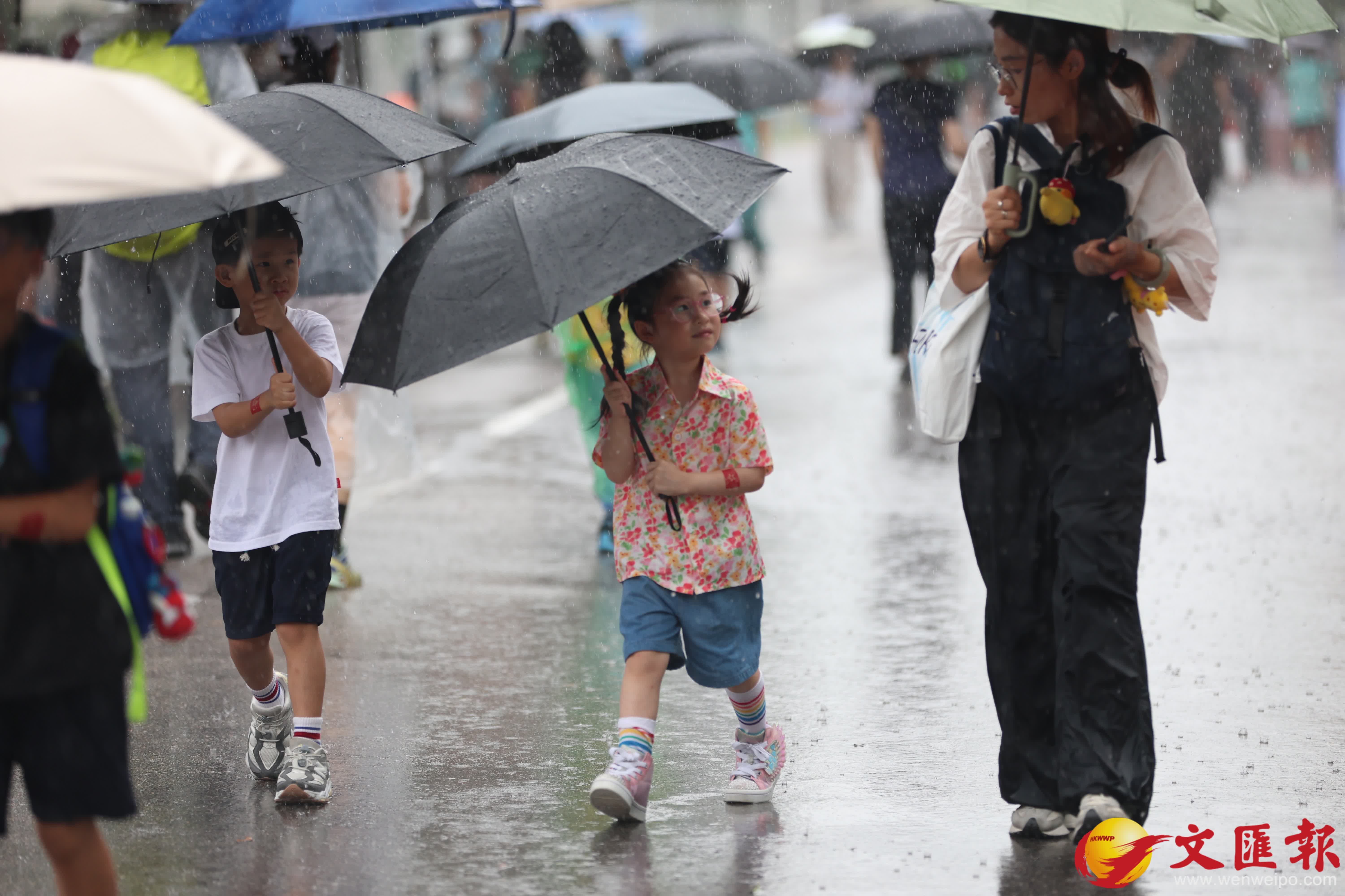 天文台發出黃色暴雨警告信號。市民在雨中前行。（香港文匯報記者萬霜靈攝）