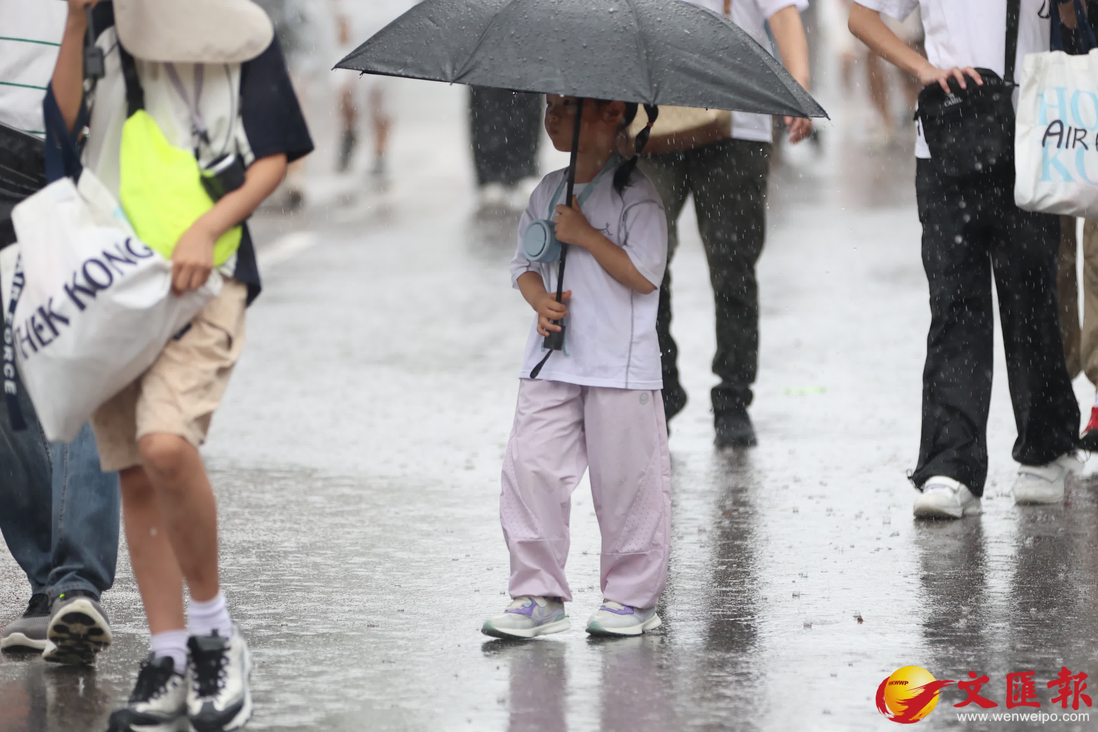 天文台發出黃色暴雨警告信號。市民在雨中前行。（香港文匯報記者萬霜靈攝）